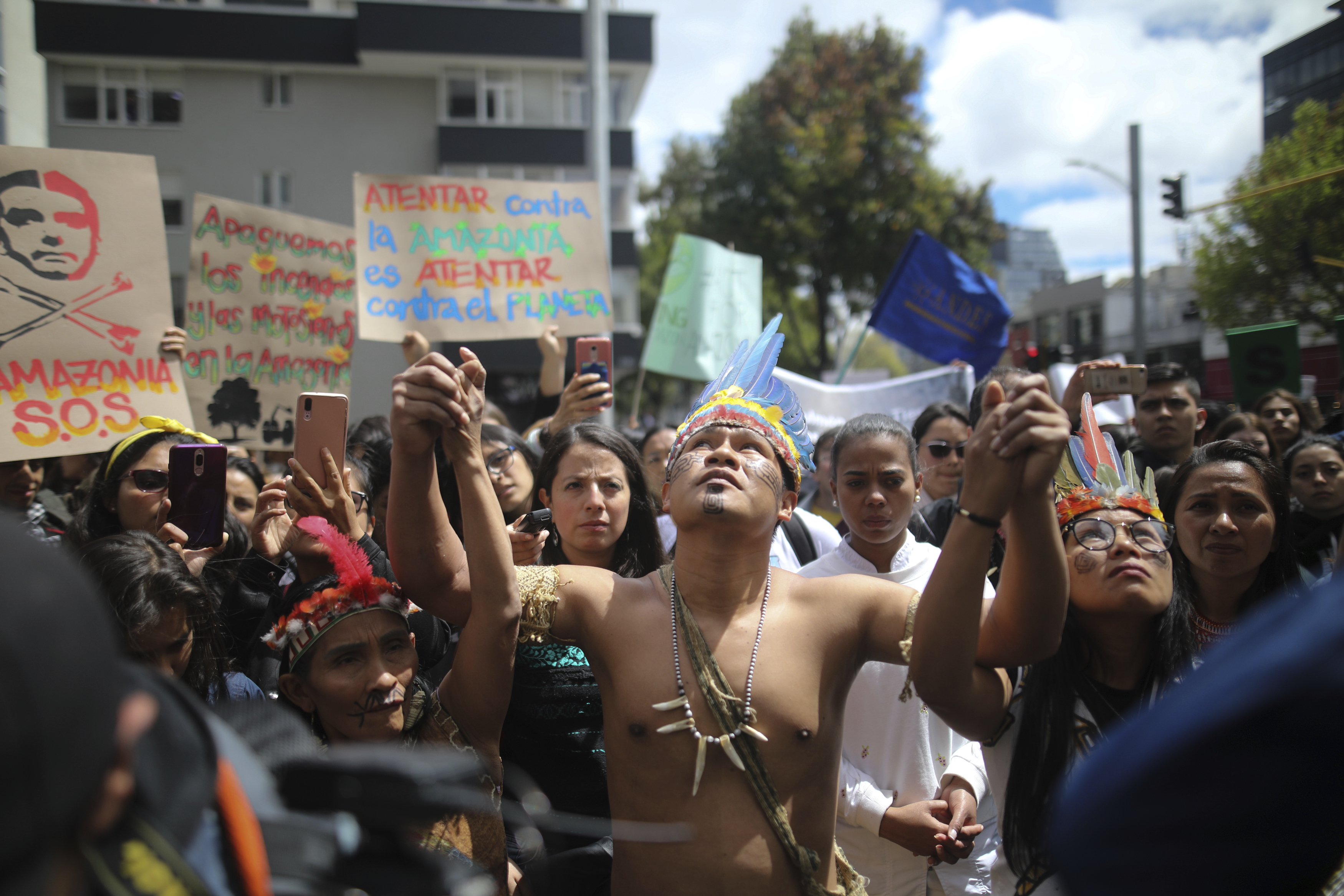 FILE - Indigenous demonstrators join a protest outside Brazilian embassy to call on Brazil's President Jair Bolsonaro to act to protect the Amazon rainforest, in Bogota, Colombia, Aug. 23, 2019. (AP Photo/Ivan Valencia, File)