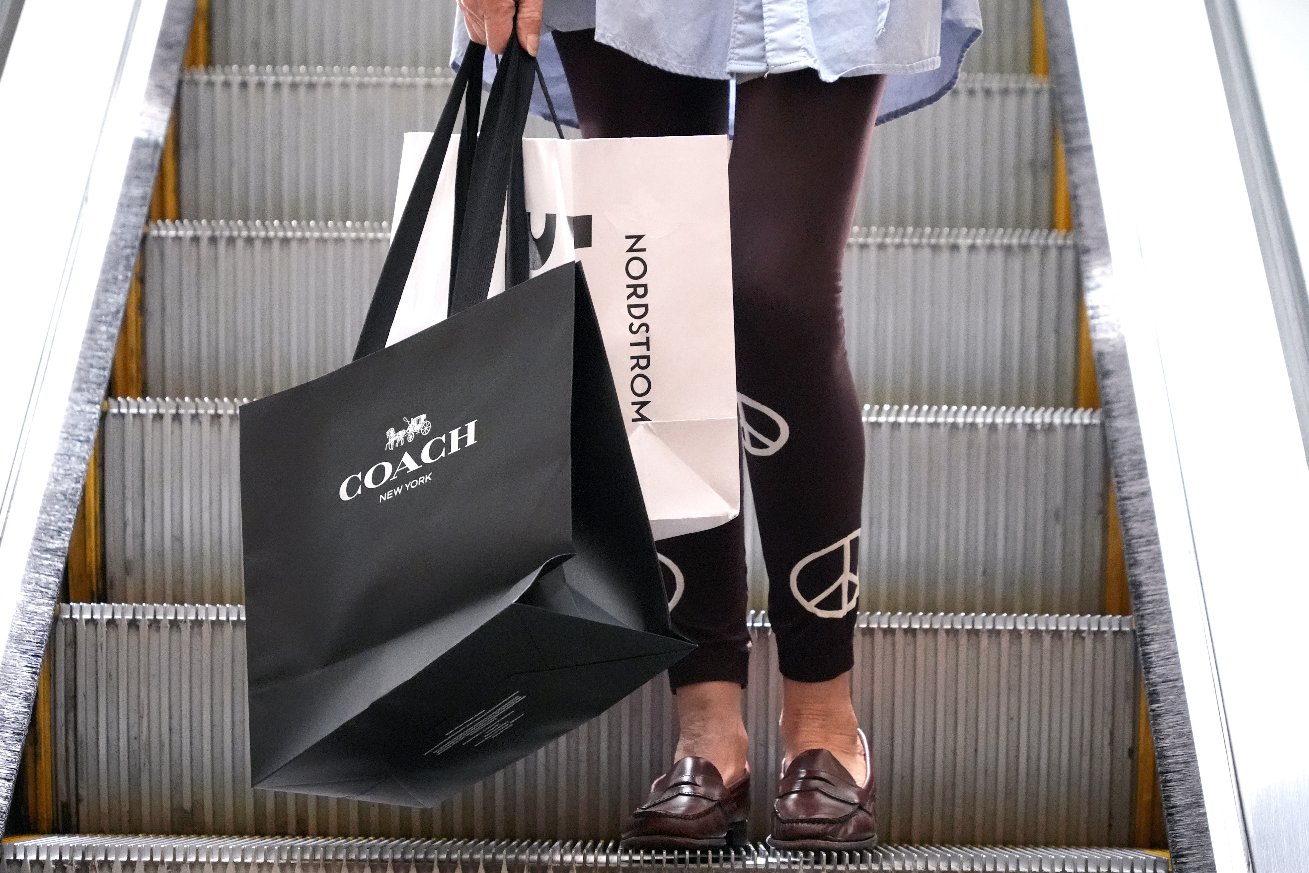 FILE - A shopper carries bags in Pittsburgh on June 3, 2024. (AP Photo/Gene J. Puskar, File)