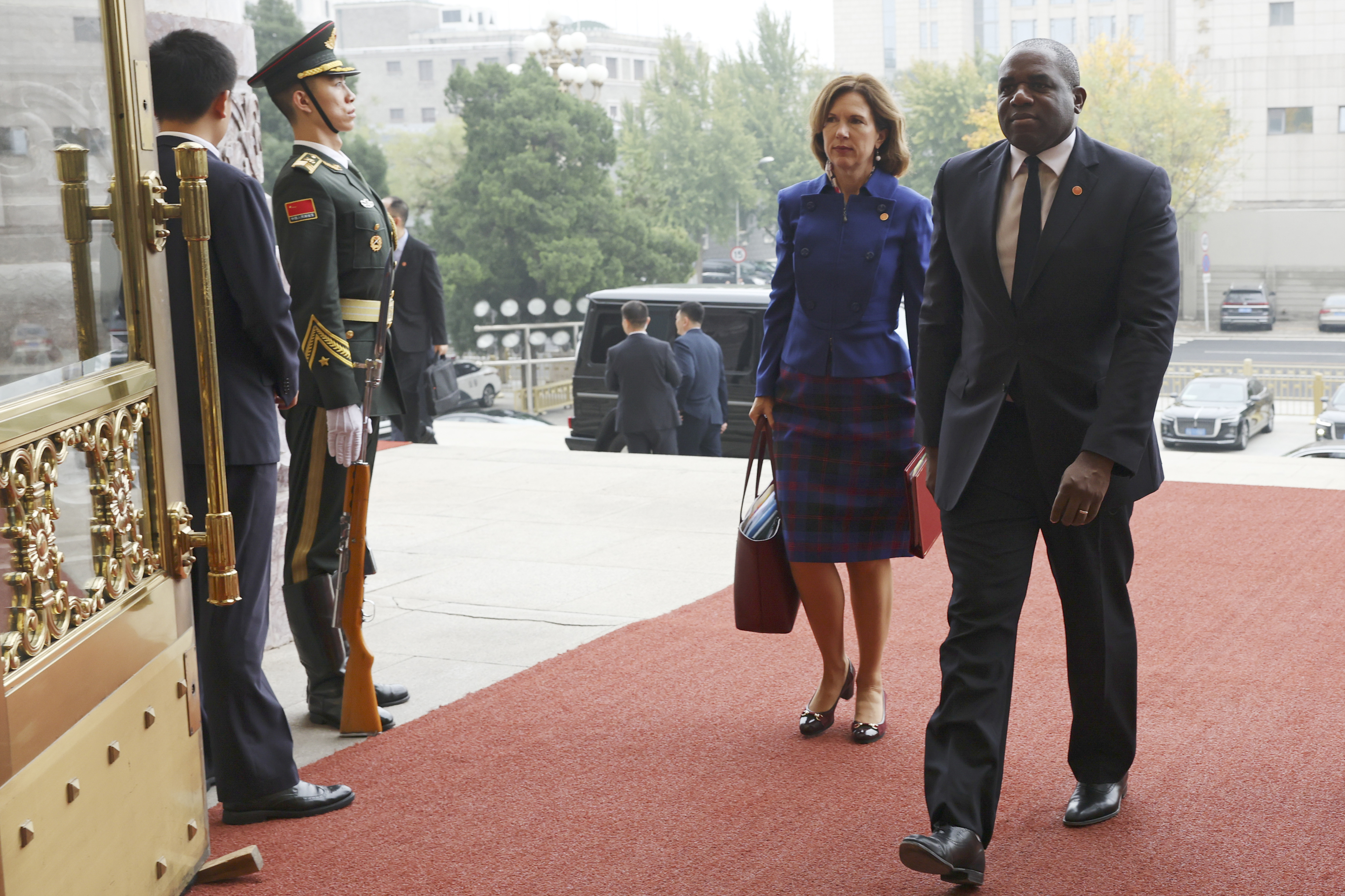 Britain's Foreign Secretary David Lammy, right, and British Ambassador to China Caroline Wilson arrive to the Great Hall of the People in Beijing Friday, Oct. 18, 2024. (Florence Lo/Pool Photo via AP)