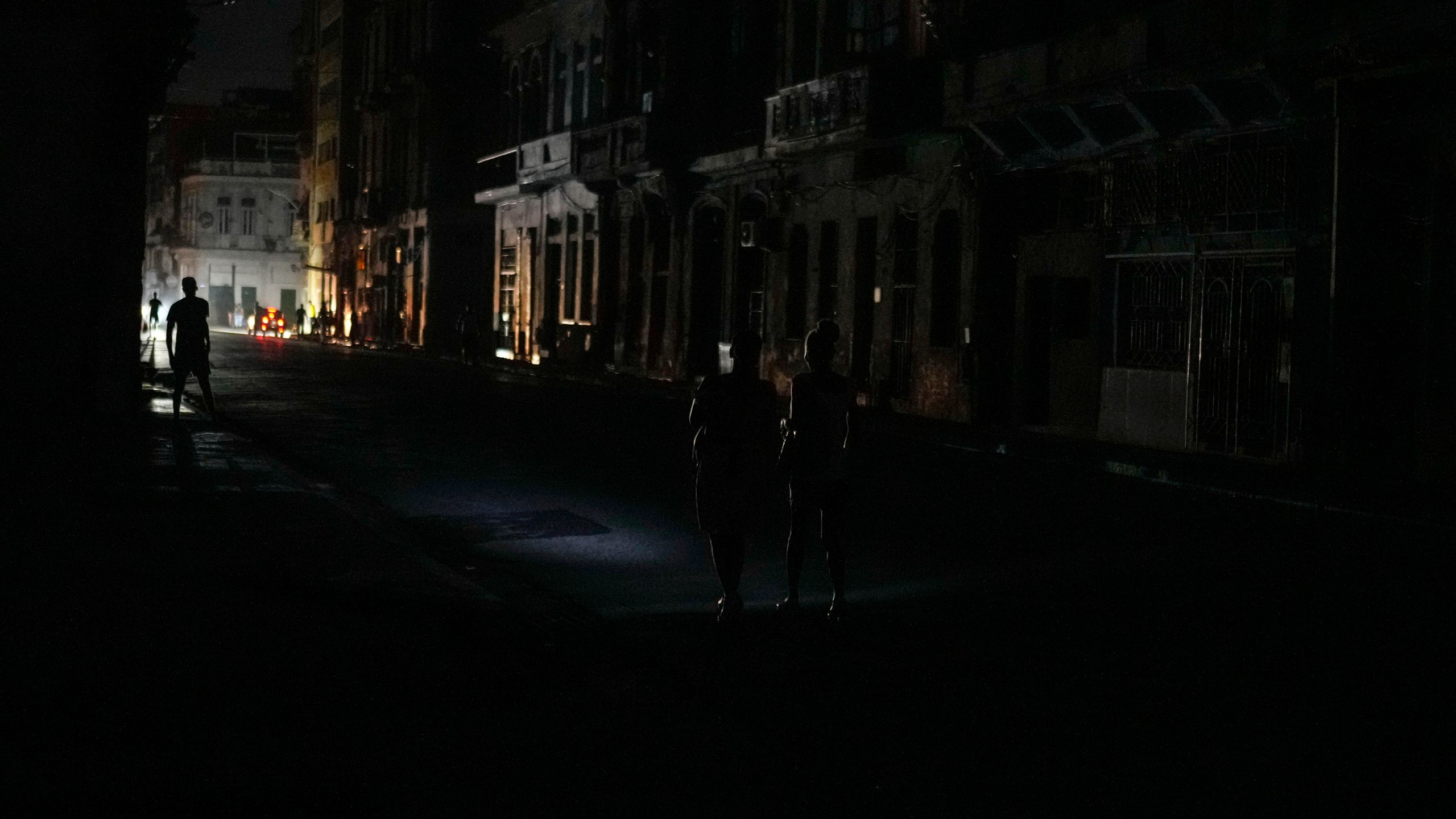 Residents walk along a street during a massive blackout after a major power plant failed in Havana, Cuba, Friday, Oct. 18, 2024. (AP Photo/Ramon Espinosa)