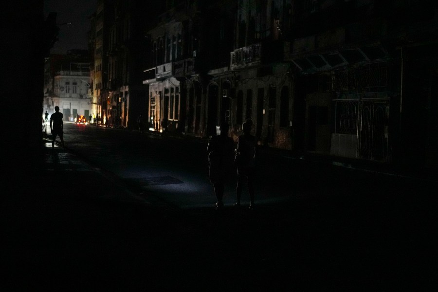 Residents walk along a street during a massive blackout after a major power plant failed in Havana, Cuba, Friday, Oct. 18, 2024. (AP Photo/Ramon Espinosa)