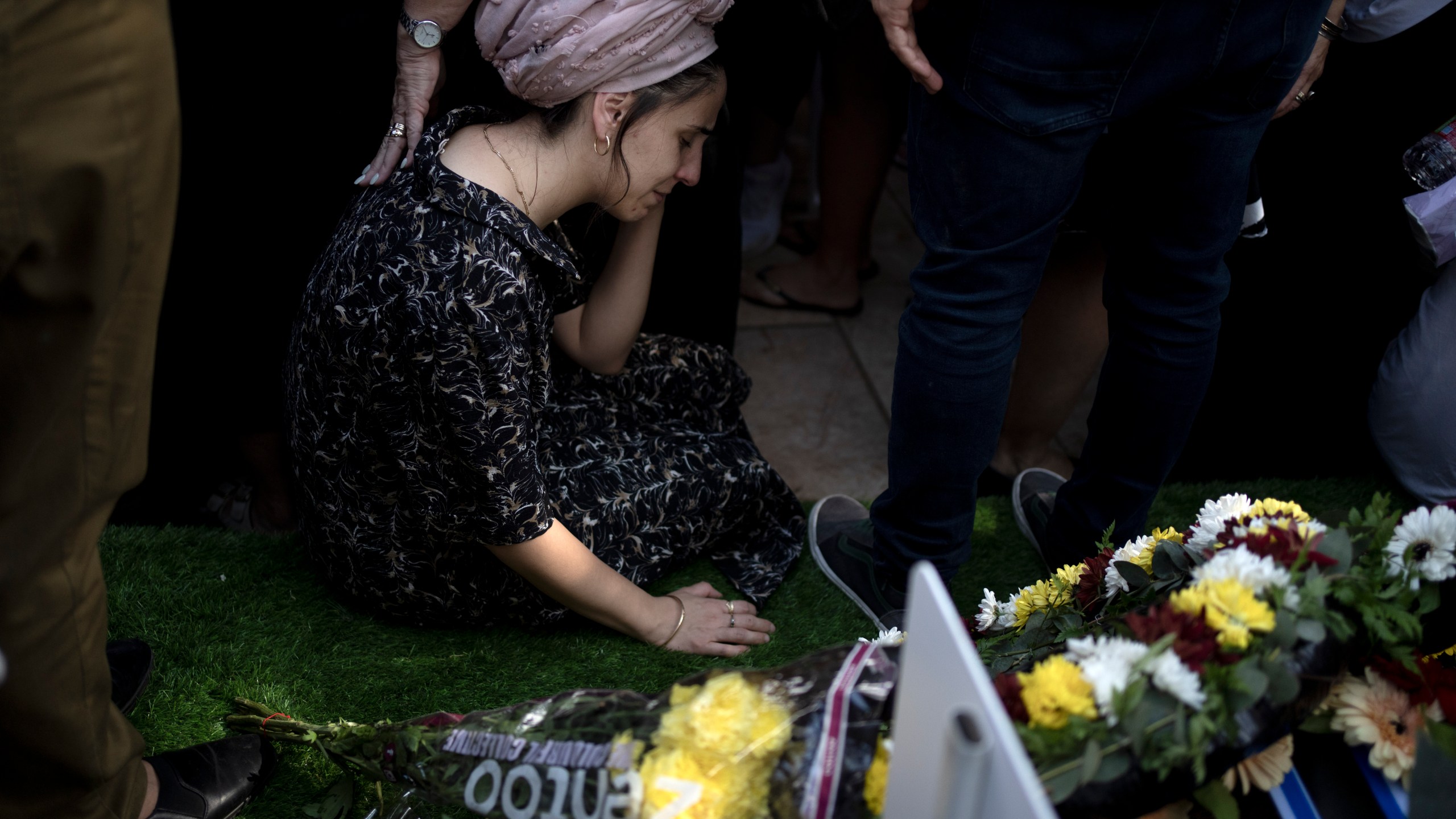 A relative weeps at the grave of Israel Defense Forces Captain Elad Siman Tov, who was killed in action in Lebanon, during his funeral in Petah Tikva, Israel, Friday, Oct. 18, 2024. (AP Photo/Maya Alleruzzo)