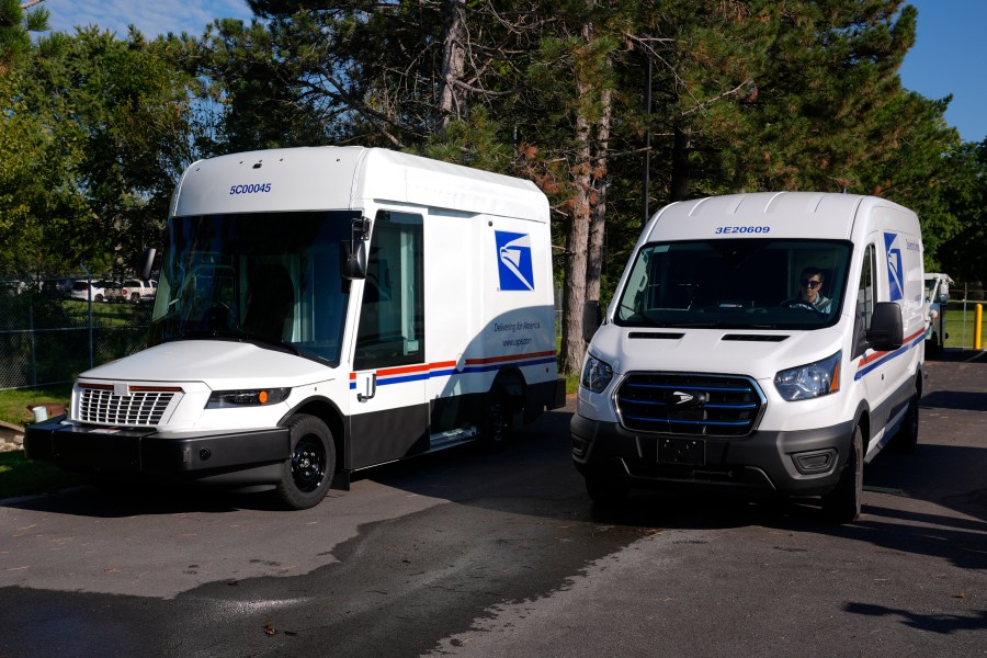 FILE - The U.S. Postal Service's next-generation delivery vehicle, left, is displayed as one new battery electric delivery trucks leaves the Kokomo Sorting and Delivery Center in Kokomo, Ind., Thursday, Aug. 29, 2024. (AP Photo/Michael Conroy, File)