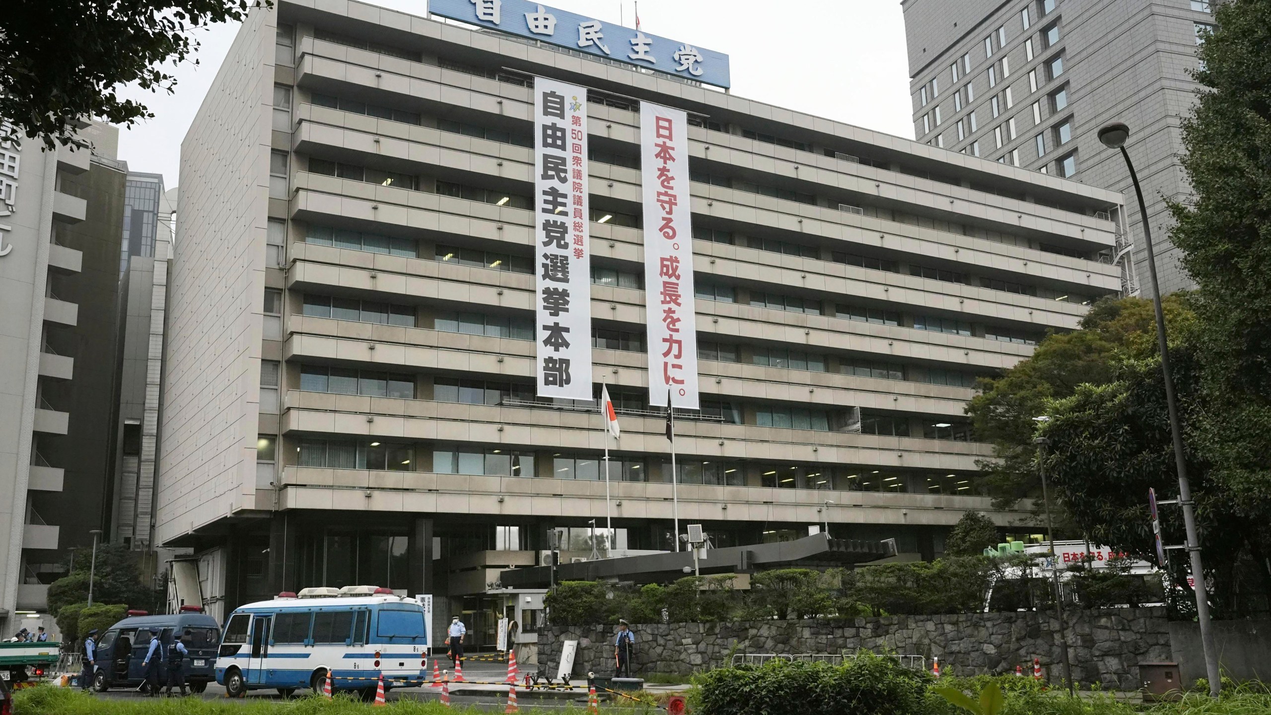 Police vehicles park near the headquarters of Japan's ruling Liberal Democratic Party in Tokyo after a man threw firebombs into the headquarters Saturday, Oct. 19, 2024. (Kyodo News via AP)