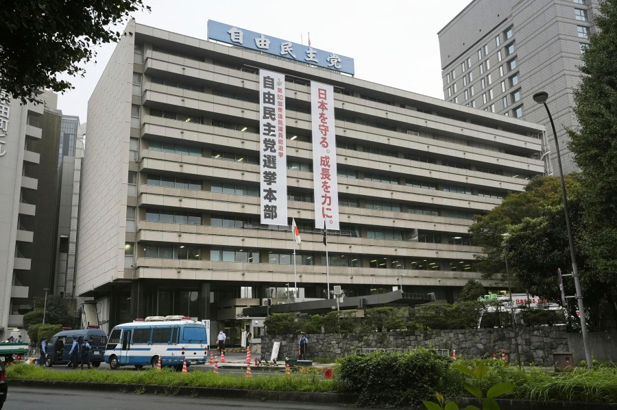 Police vehicles park near the headquarters of Japan's ruling Liberal Democratic Party in Tokyo after a man threw firebombs into the headquarters Saturday, Oct. 19, 2024. (Kyodo News via AP)