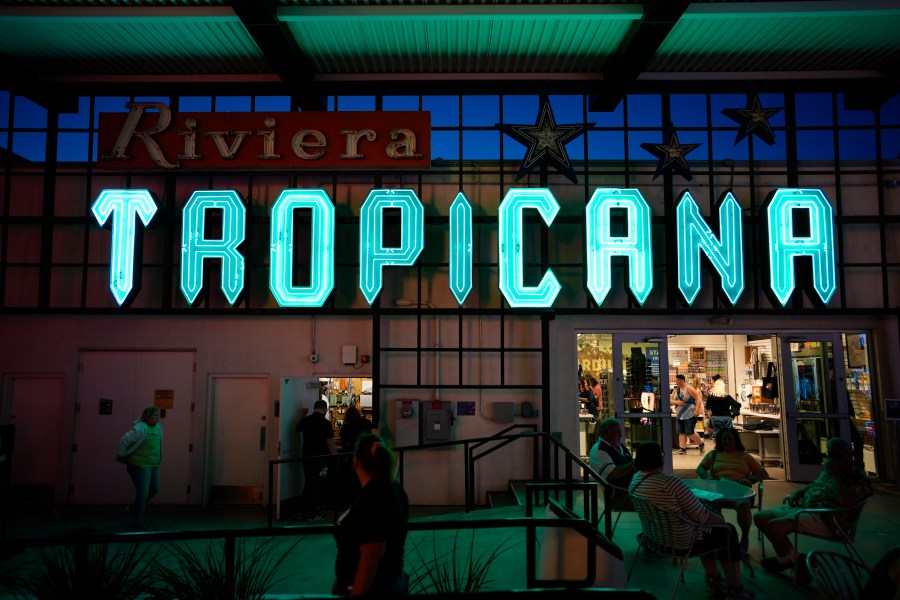 People walk by a sign for the Tropicana on display at the Neon Museum, Wednesday, April 3, 2024, in Las Vegas. (AP Photo/John Locher)