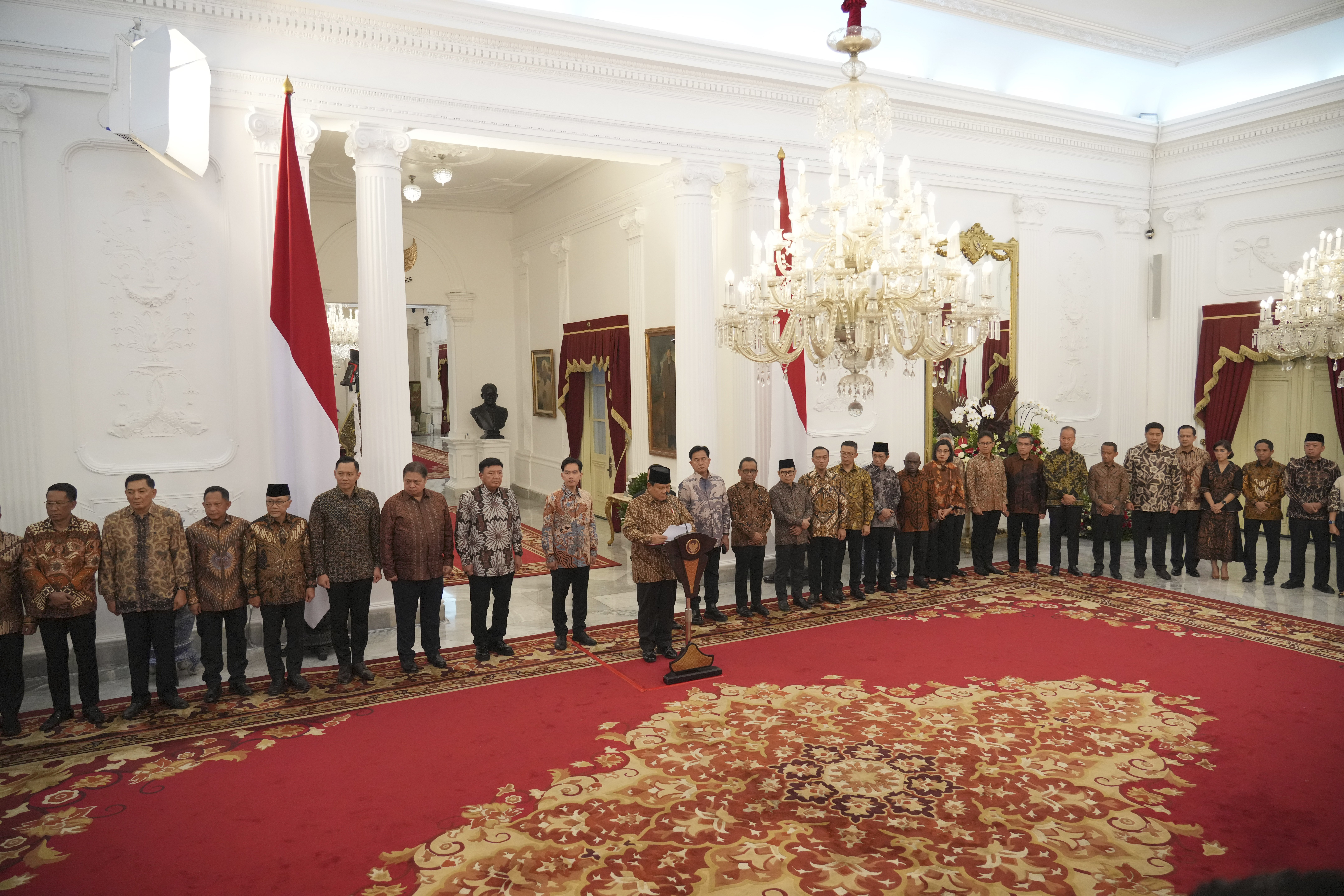 Newly appointed cabinet ministers stand behind Indonesia's new President Prabowo Subianto, center, as he announces his cabinet lineup at Merdeka Palace in Jakarta, Indonesia, Sunday, Oct. 20, 2024. (AP Photo/Achmad Ibrahim)