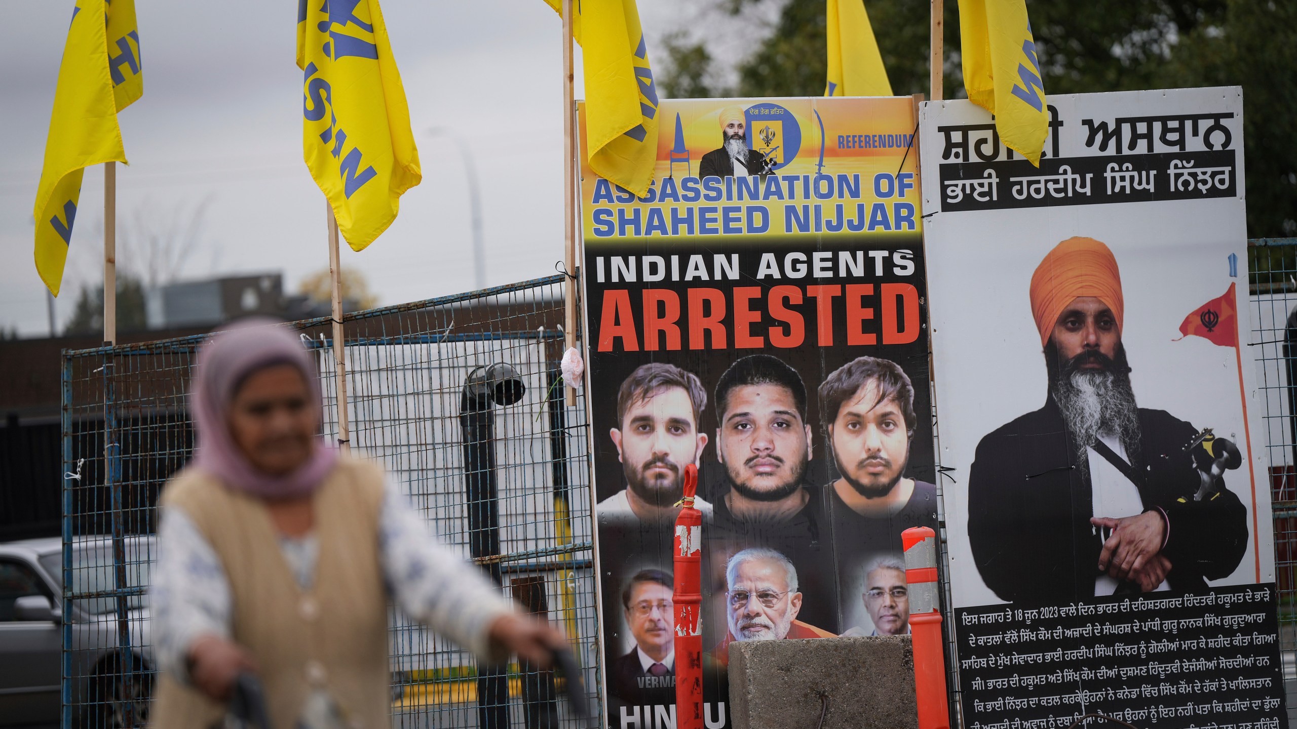 A photograph of late temple president Hardeep Singh Nijjar, back right, is displayed outside the Guru Nanak Sikh Gurdwara Sahib, in Surrey, British Columbia, Tuesday, Oct. 15, 2024. (Darryl Dyck/The Canadian Press via AP)