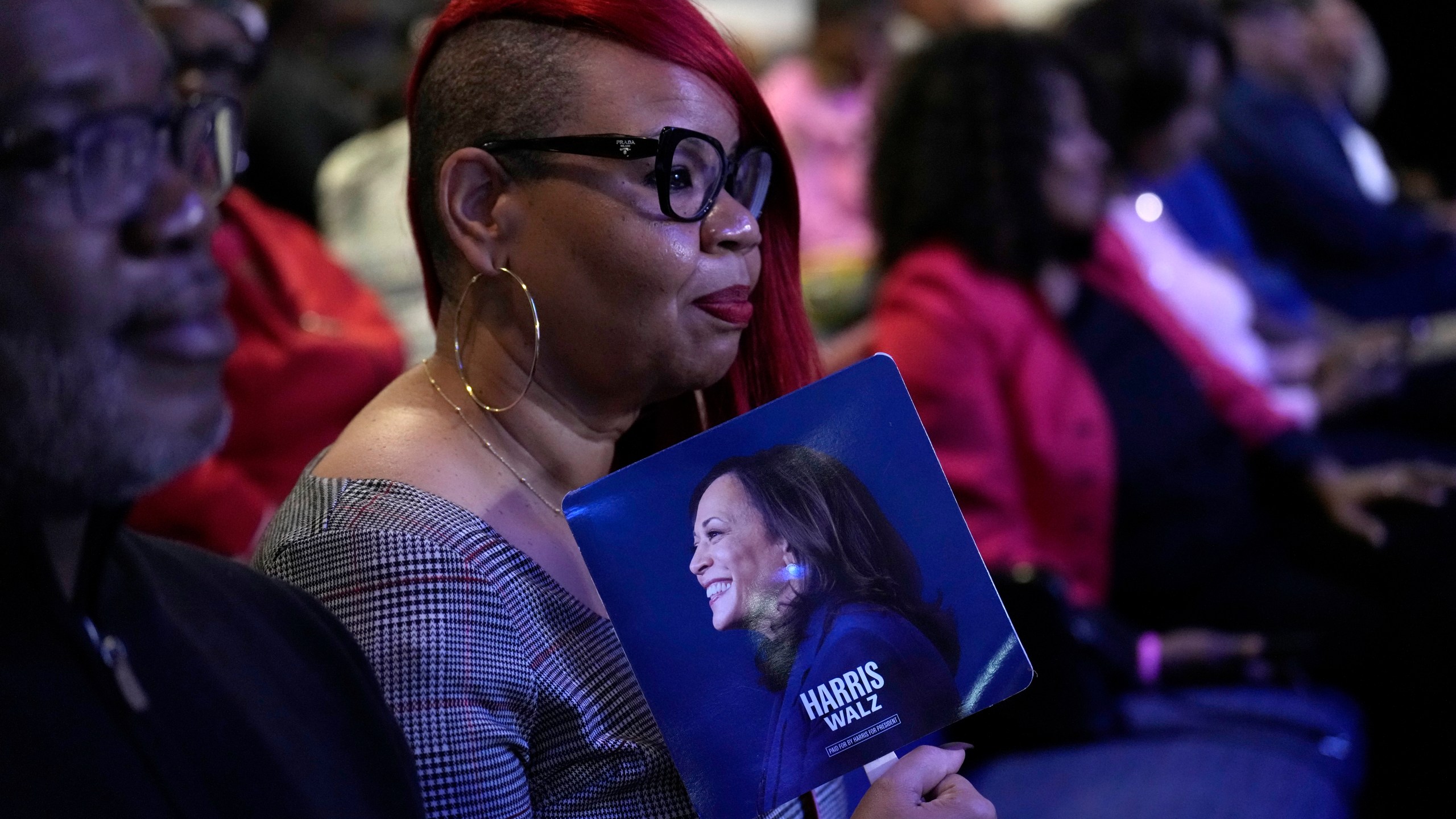 An attendee holds a campaign fan before Democratic presidential nominee Vice President Kamala Harris arrives to speak during a church service and early vote event at Divine Faith Ministries International, Sunday, Oct. 20, 2024, in Jonesboro, Ga. (AP Photo/Jacquelyn Martin)