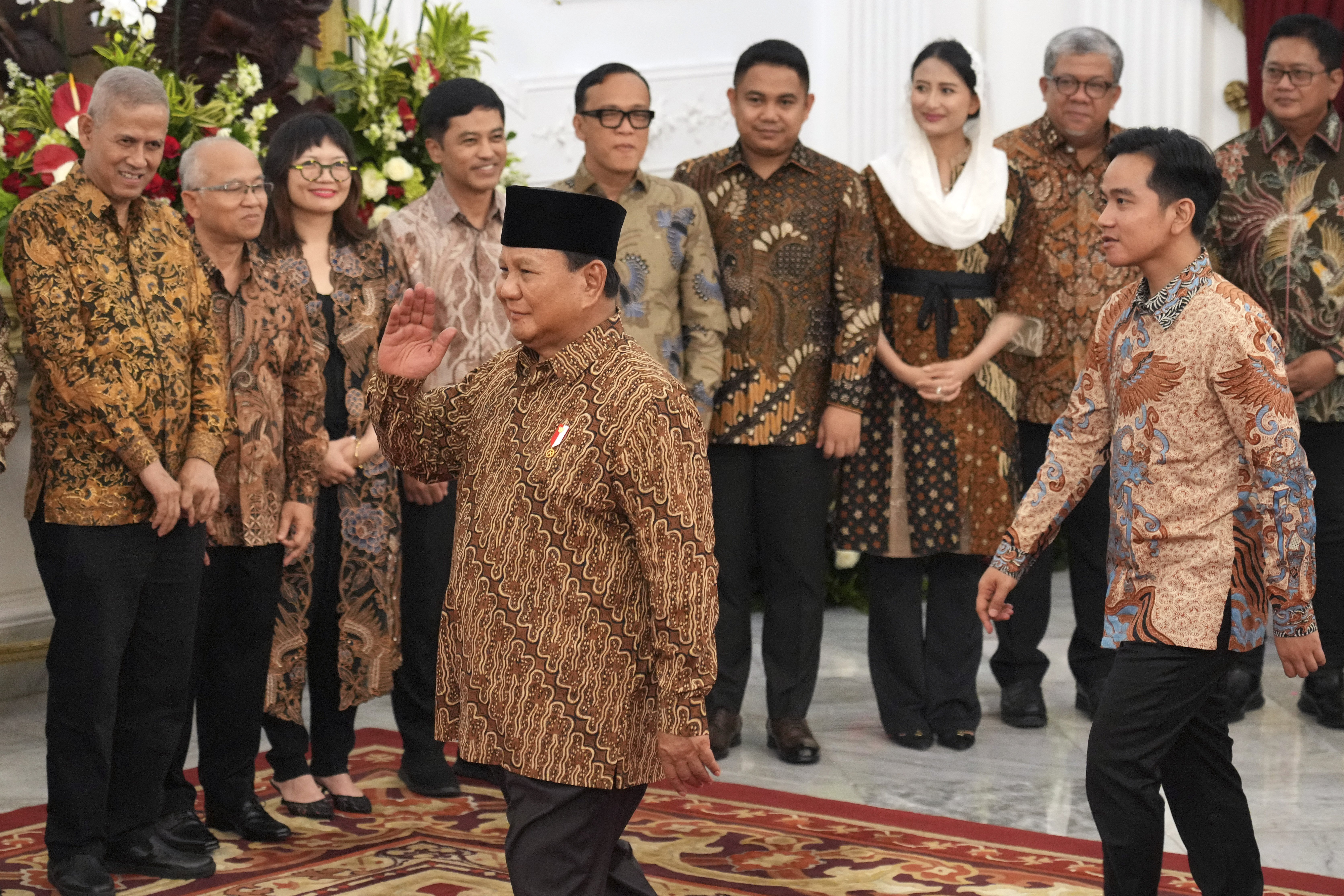 Indonesia's new President Prabowo Subianto, foreground, and Vice President Gibran Rakabuming Raka, right, greet newly-appointed deputy ministers during the announcement of their cabinet lineup at Merdeka Palace in Jakarta, Indonesia, Sunday, Oct. 20, 2024. (AP Photo/Achmad Ibrahim)