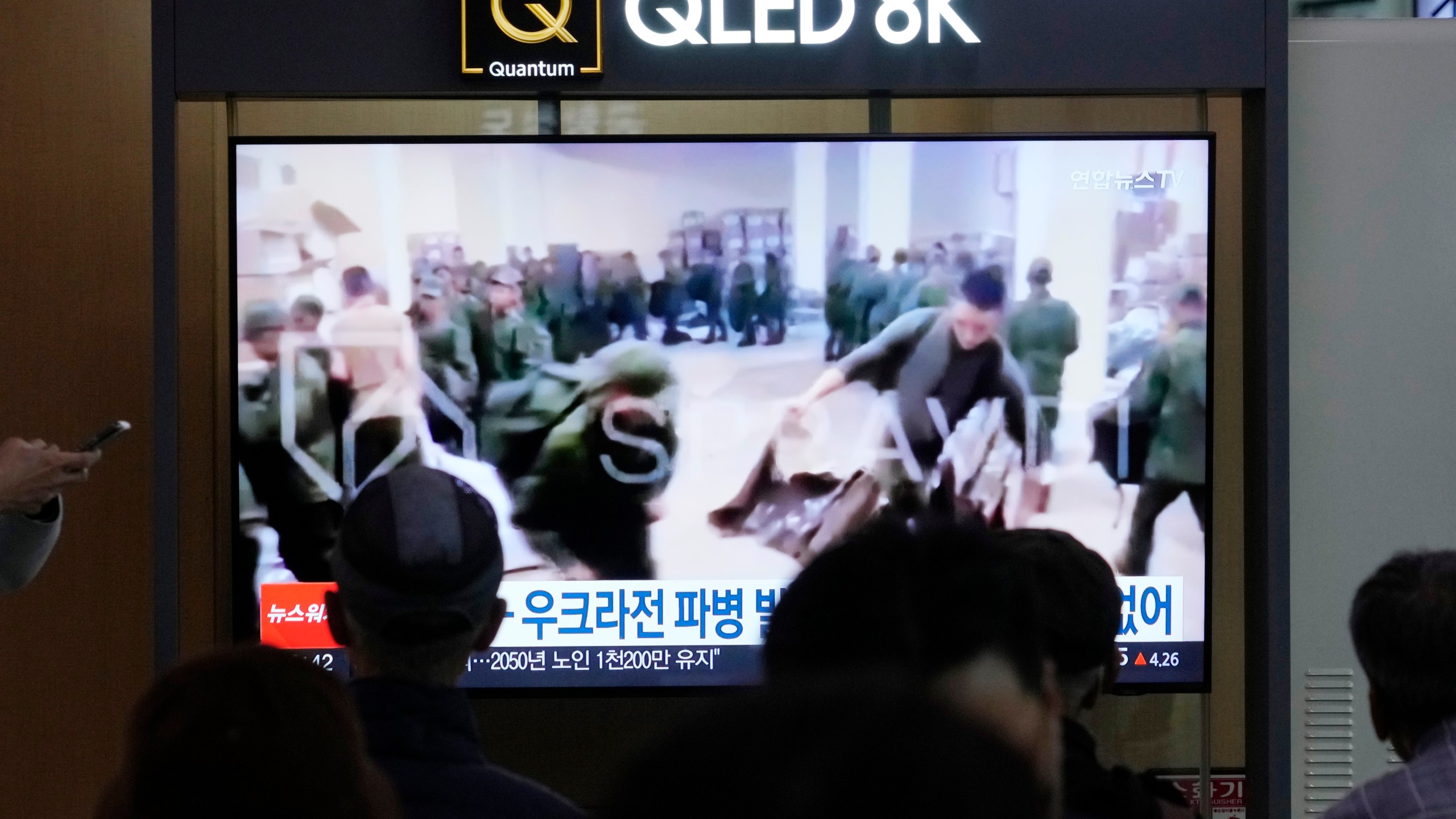 A TV screen shows an image of soldiers believed to be from North Korea stand in line to receive supplies from Russia during a news program at Seoul Railway Station in Seoul, South Korea, Monday, Oct. 21, 2024. (AP Photo/Ahn Young-joon)