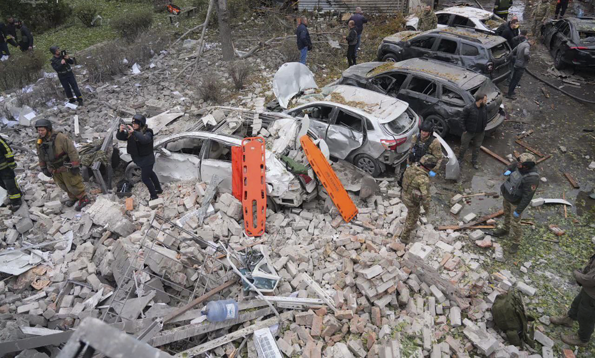 In this photo provided by the Ukrainian Emergency Service, emergency workers clear the rubble after Russia attacked the city with guided bombs overnight in Zaporizhzhia, Ukraine, Monday, Oct. 21, 2024. (Ukrainian Emergency Service via AP)