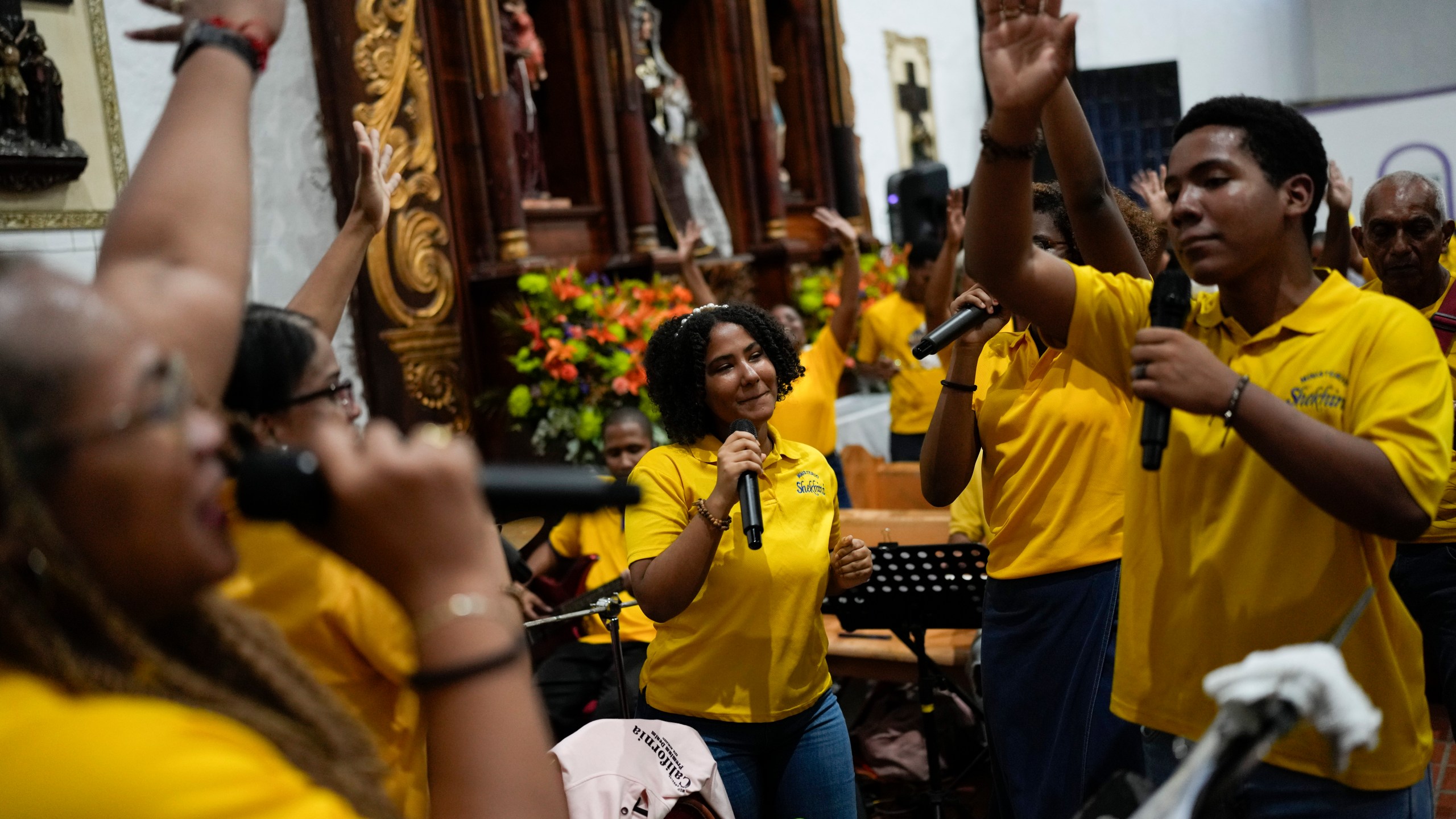 Pilgrims sing and dance inside San Felipe Church to honor the Black Christ in Portobelo, Panama, Monday, Oct. 21, 2024, during a festival celebrating the iconic statue that was found on the shore in 1658. (AP Photo/Matias Delacroix)