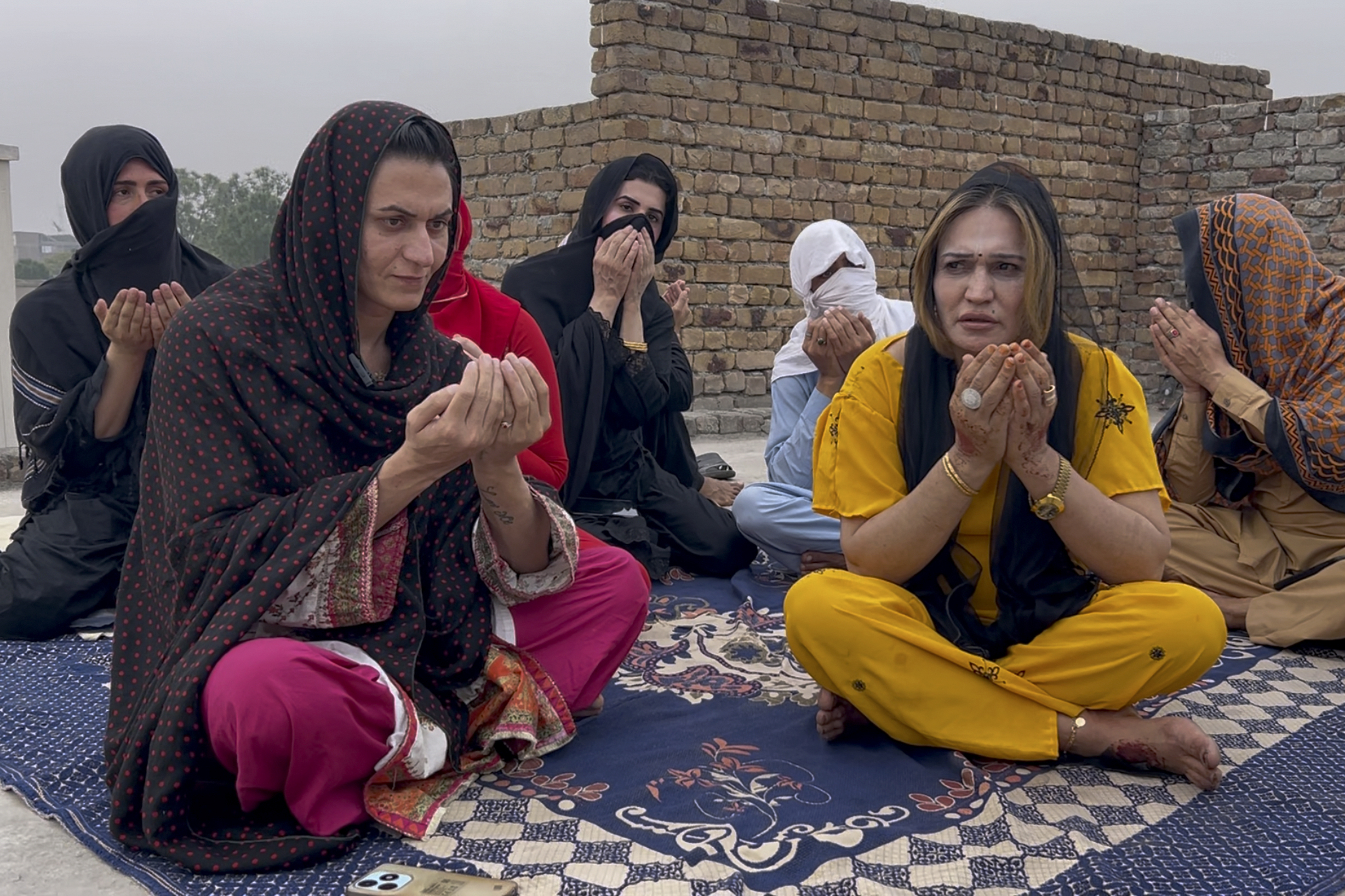 Transgender persons attend a prayer ceremony for their colleagues, who were killed by two men armed with daggers at their home, in Mardan, a city in Pakistan's Khyber Pakhtunkhwa province, Tuesday, Oct. 22, 2024. (AP Photo/Arif Khan)