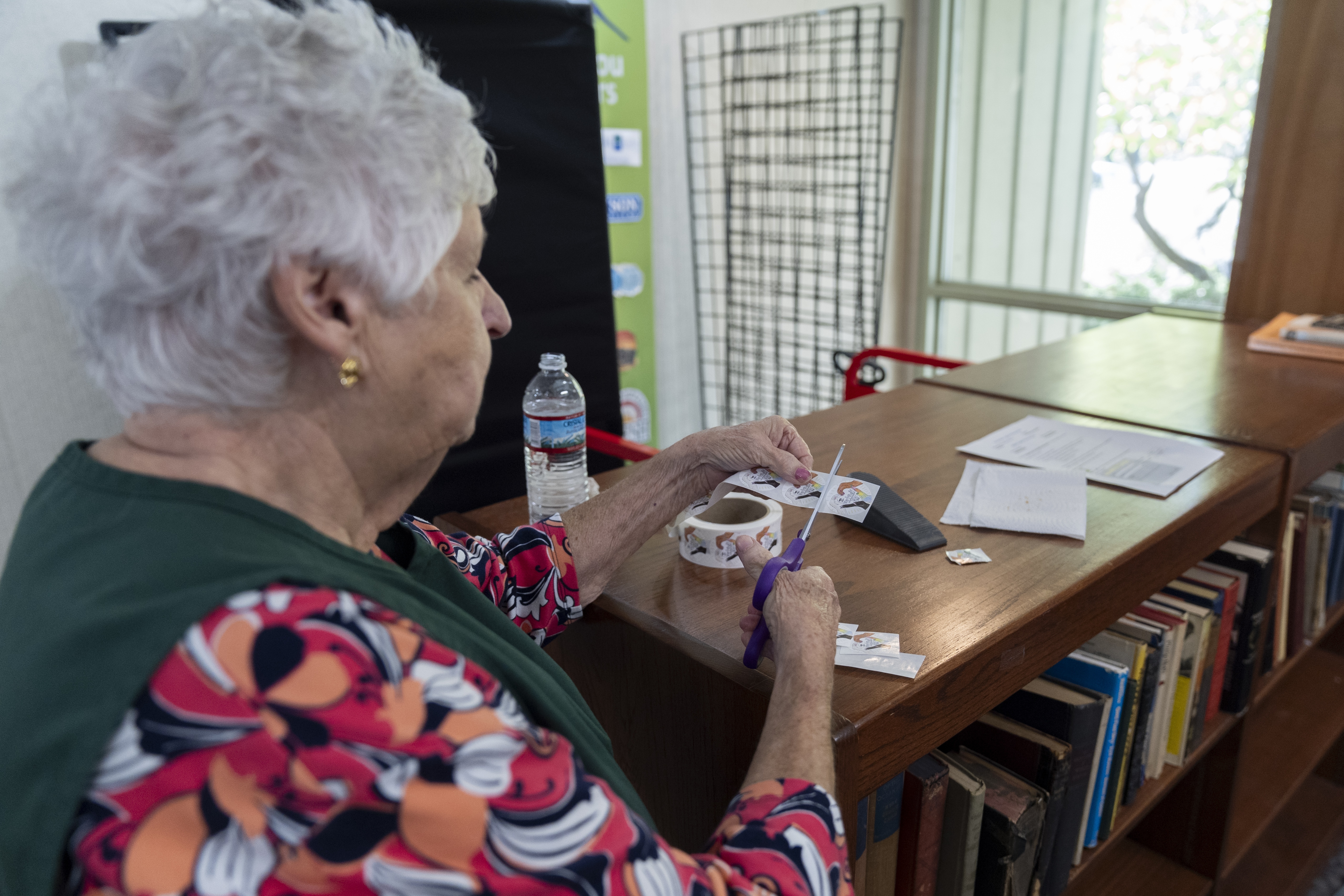 An election official prepares stickers for voters who have cast their ballots during the first day of early in-person voting in Black Mountain, N.C., Thursday, Oct. 17, 2024. (AP Photo/Stephanie Scarbrough)