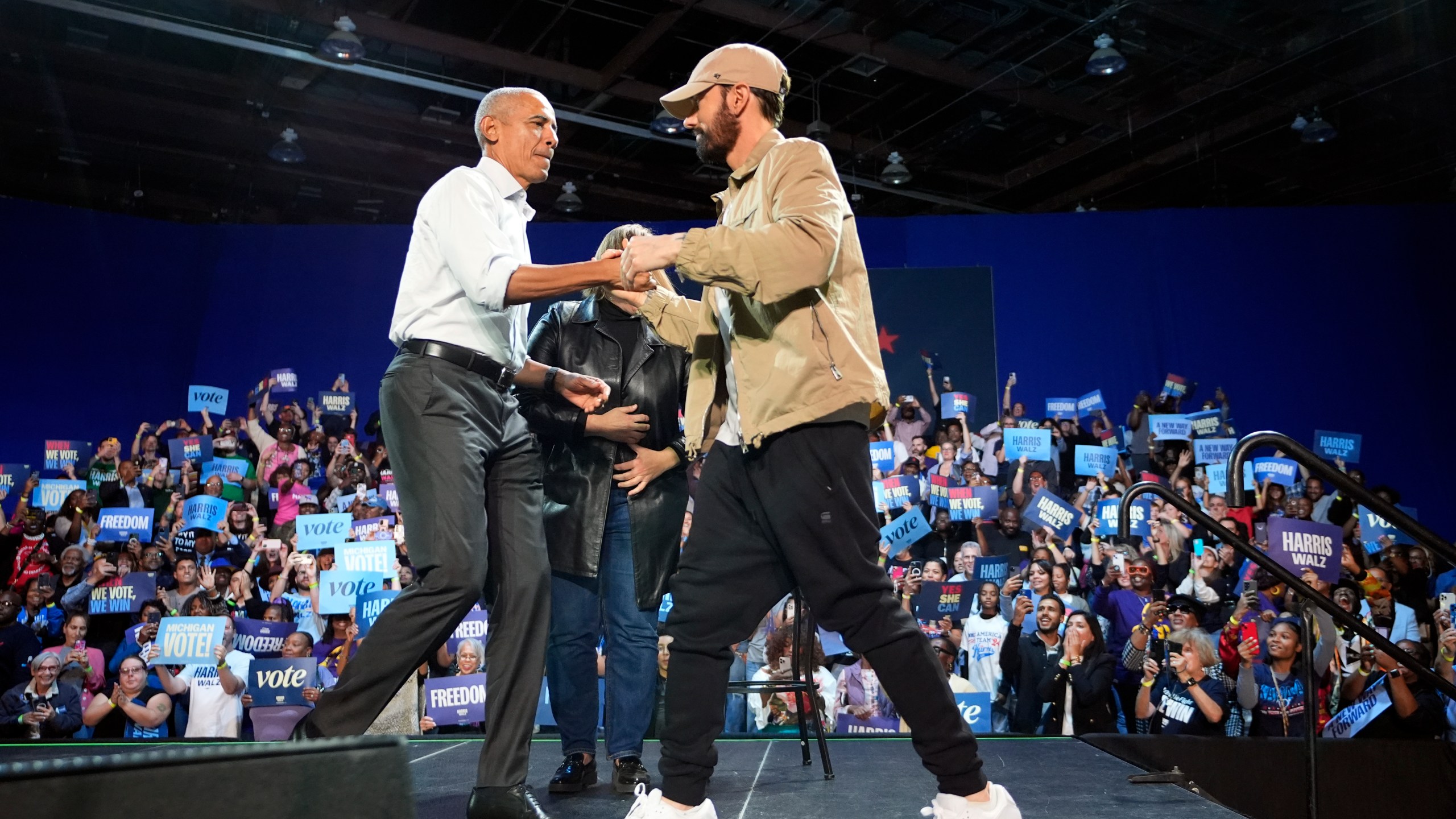 Rapper Eminem, right, greets former President Barack Obama, left, on stage at a campaign rally supporting Democratic presidential nominee Vice President Kamala Harris, Tuesday, Oct. 22, 2024, in Detroit. (AP Photo/Paul Sancya)