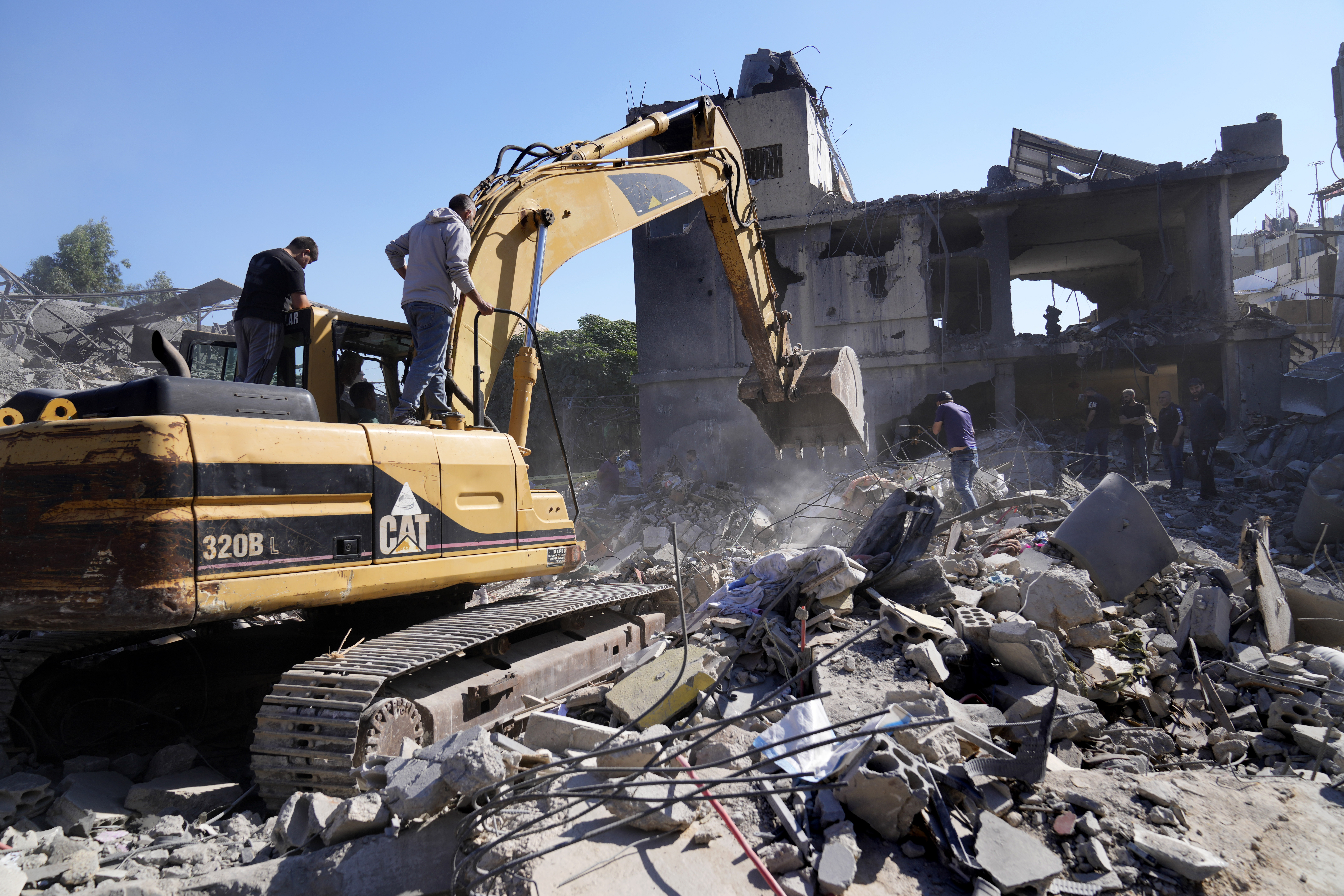 A bulldozer clears the rubble of destroyed buildings following Israeli airstrikes in a densely-populated neighbourhood facing the city's main government hospital, in southern Beirut, Lebanon, Tuesday, Oct. 22, 2024. (AP Photo/Hussein Malla)