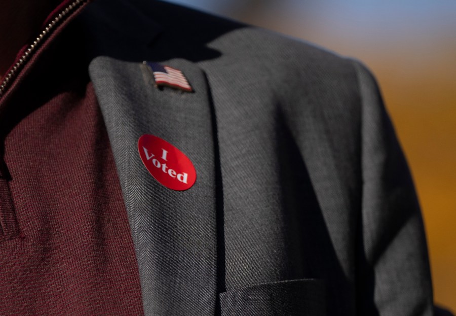 Democratic vice presidential nominee Minnesota Gov. Tim Walz wears an "I voted" sticker as he speaks to the press after early voting at the Ramsey County Elections office in St. Paul, Minn., Wednesday, Oct. 23, 2024. (Renée Jones Schneider/Star Tribune via AP, Pool)