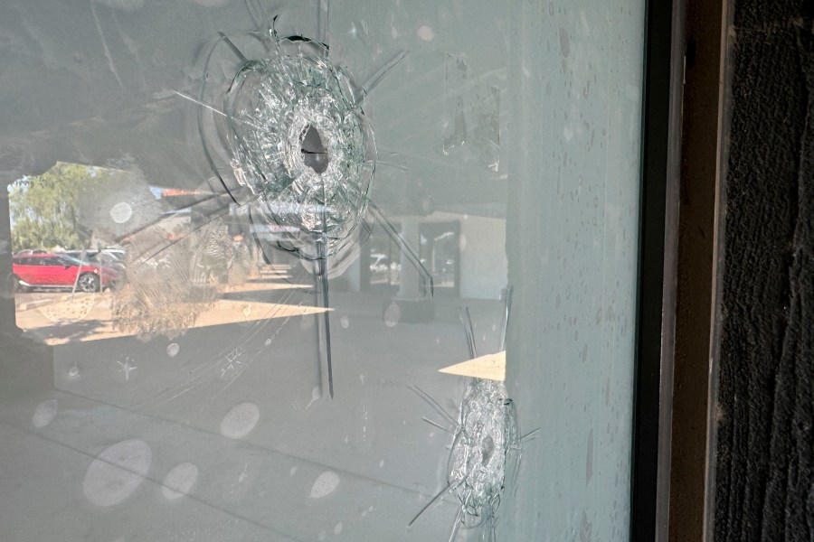 Bullet holes remain in the glass window at a Democratic Party campaign office in Tempe, Ariz., Wednesday, Sept. 25, 2024. (AP Photo/Gabriel Sandoval)