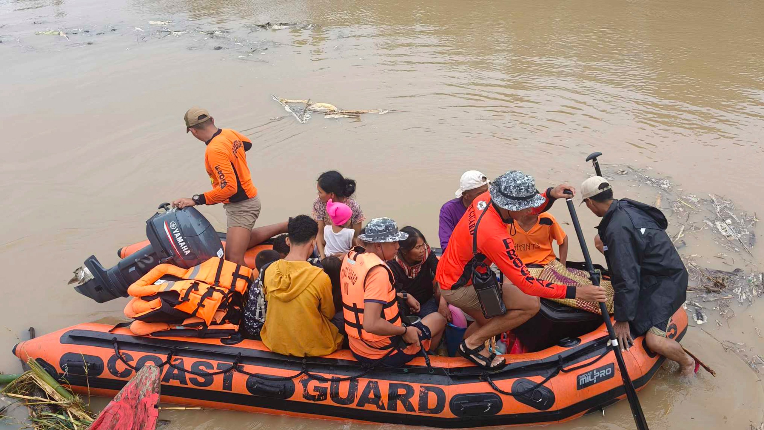 Residents are ferried on a rubber boat after being rescued from their roofs where they stayed to avoid high floods caused by Tropical Storm Trami hit Libon town, Albay province, Philippines on Wednesday Oct. 23, 2024. (Michelle Ricasio via AP)