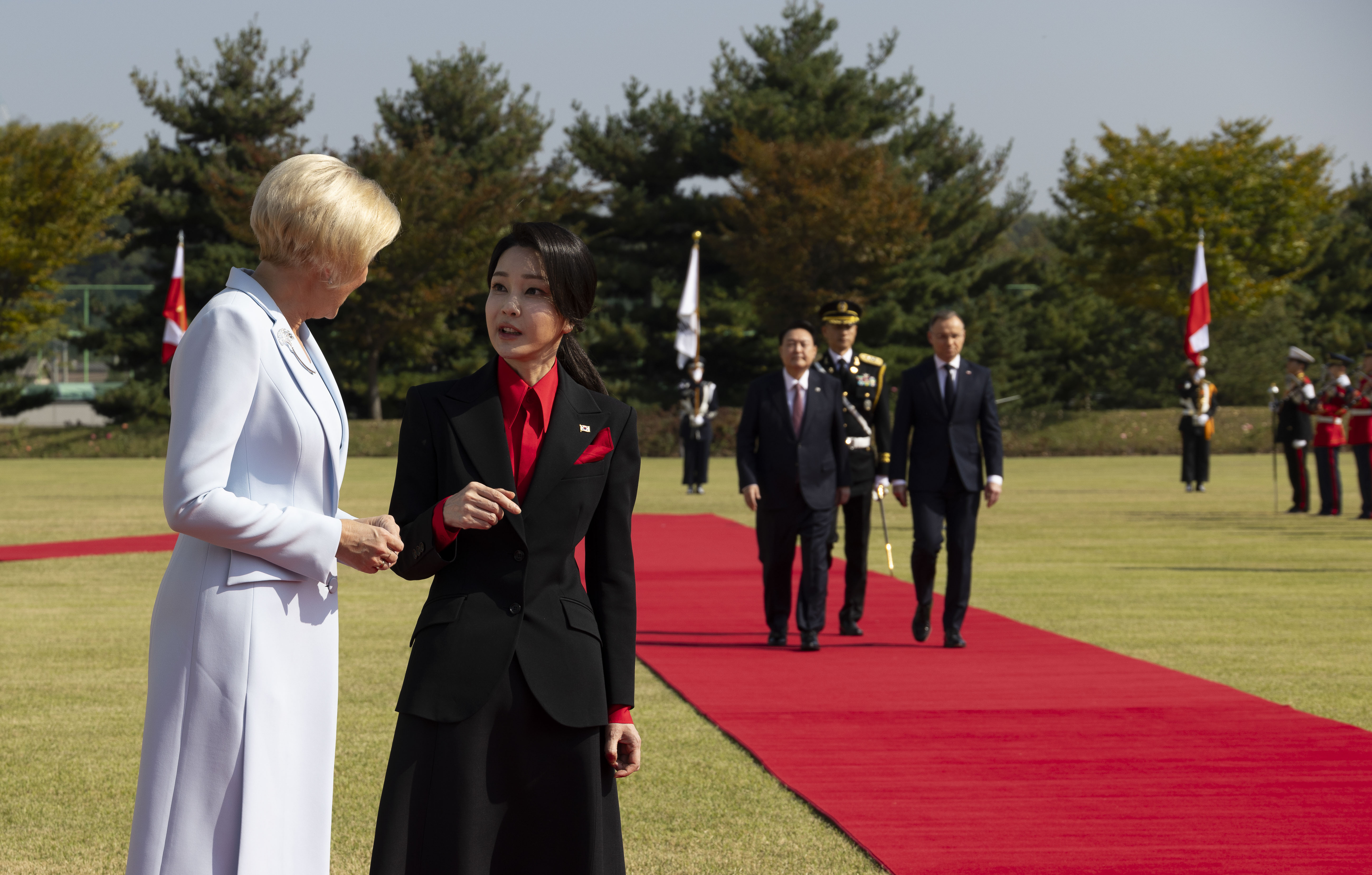 South Korean first lady Kim Keon-Hee, second from left, talks with Polish first lady Agata Kornhauser-Duda, left, as South Korea's President Yoon Suk Yeol, third from left, and Poland's President Andrzej Duda, right, walk with honor guards during a welcoming ceremony at the Presidential Office in Seoul, South Korea, Thursday, Oct. 24, 2024. (Jeon Heon-Kyun/Pool Photo via AP)