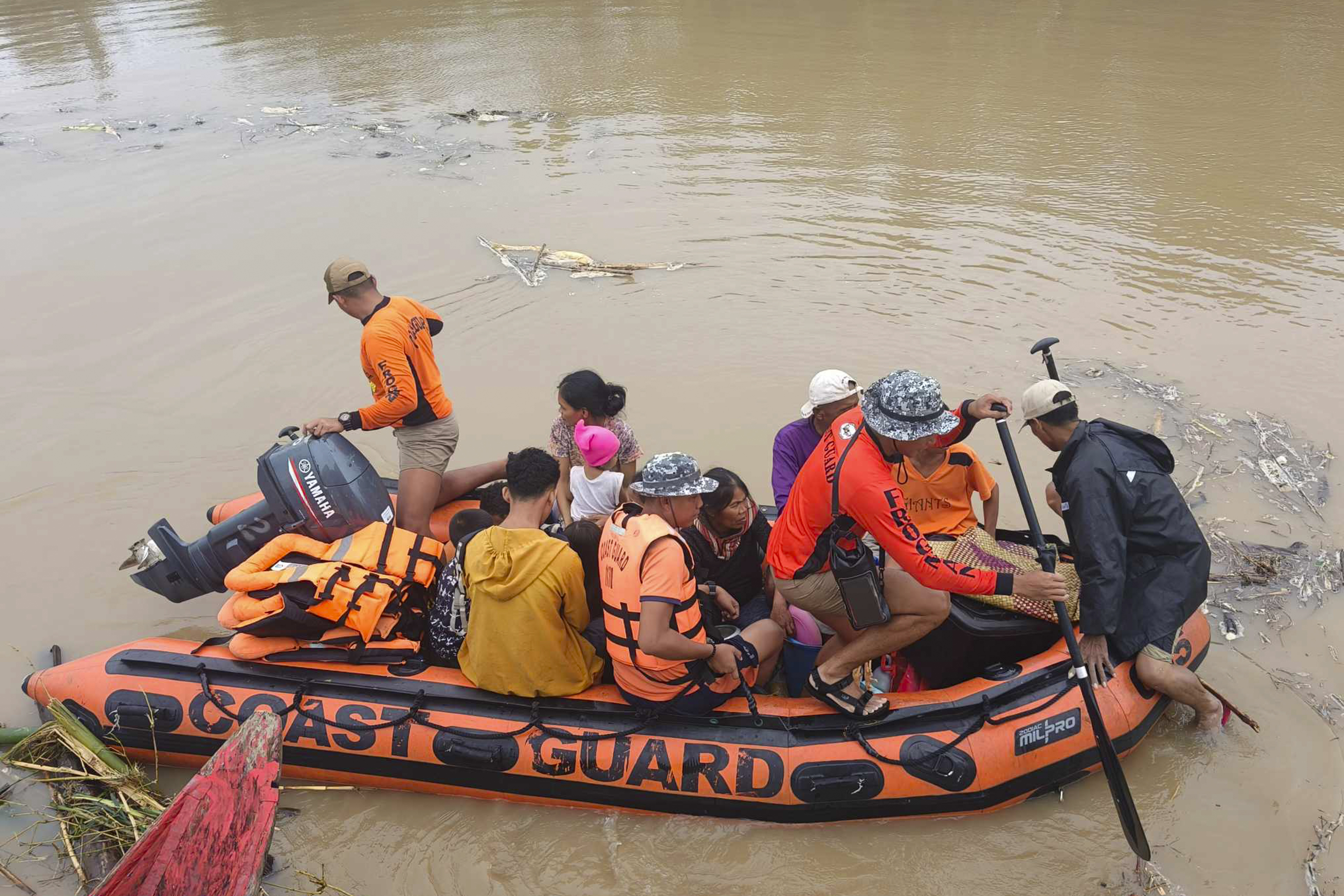 Residents are ferried on a rubber boat after being rescued from their roofs where they stayed to avoid high floods caused by Tropical Storm Trami hit Libon town, Albay province, Philippines on Wednesday Oct. 23, 2024. (Michelle Ricasio via AP)