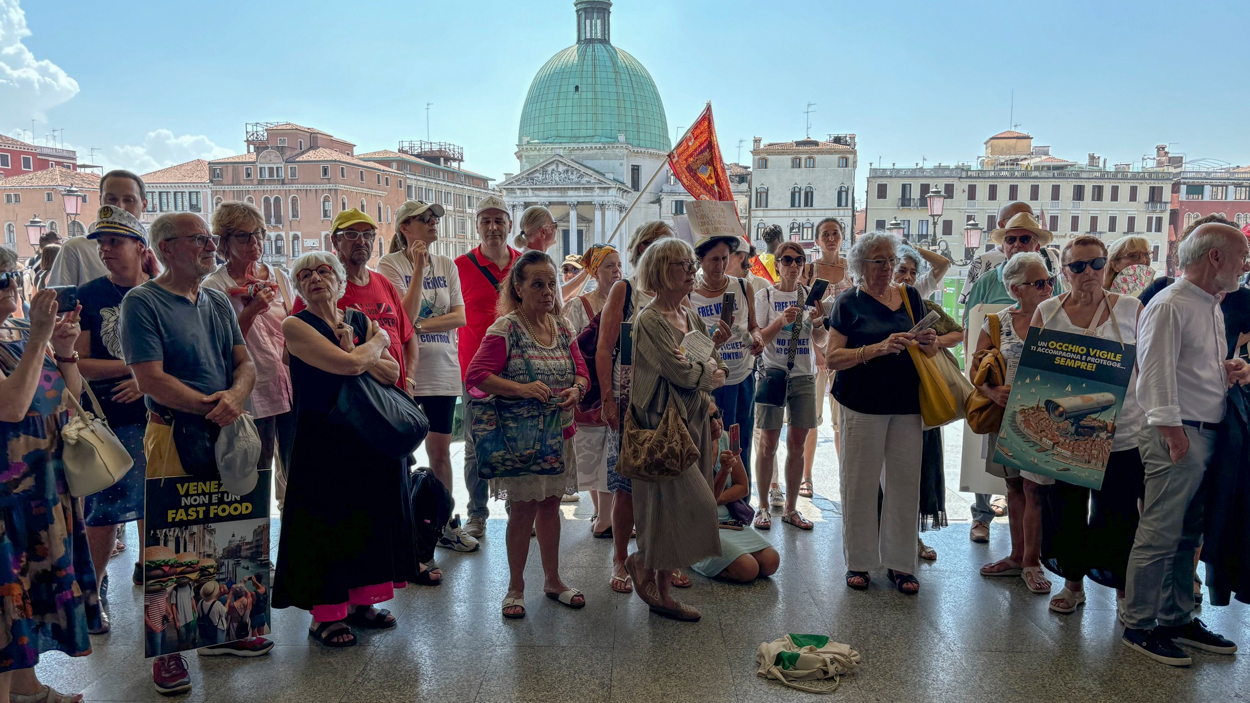 FILE - Activists gather outside Venice's Santa Lucia train station, July 13, 2024, to protest a day-tripper fee that they say has failed to dissuade visitors from arriving on peak days, as envisioned. (AP Photo/Colleen Barry, File)