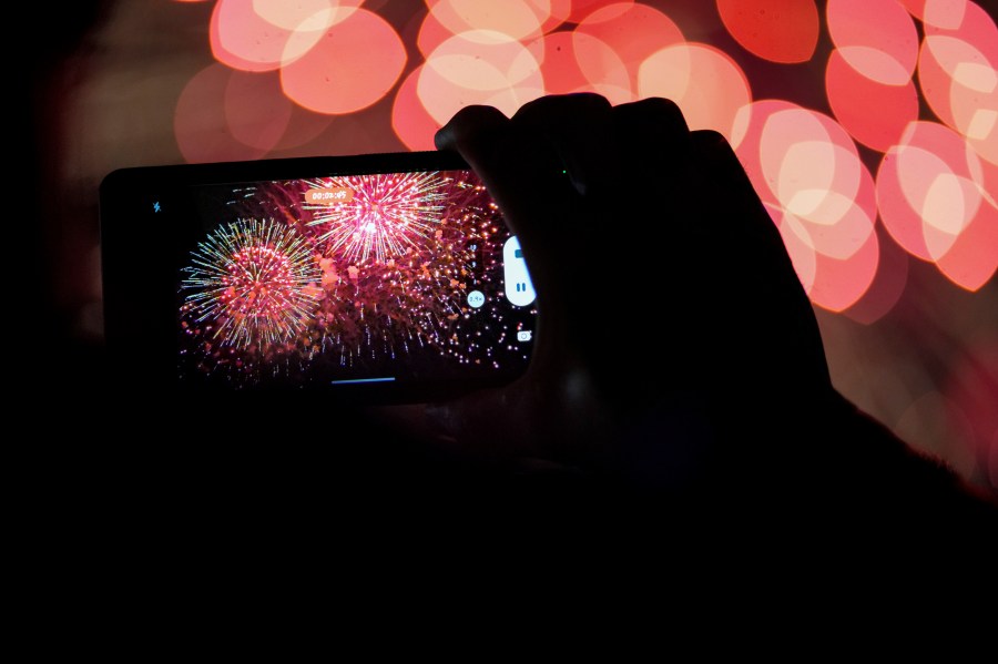 FILE - A spectator records a cell phone video as fireworks are launched over the Ohio River during the Western & Southern WEBN Fireworks show in Cincinnati on Sept. 3, 2023, in Cincinnati. (AP Photo/Aaron Doster)