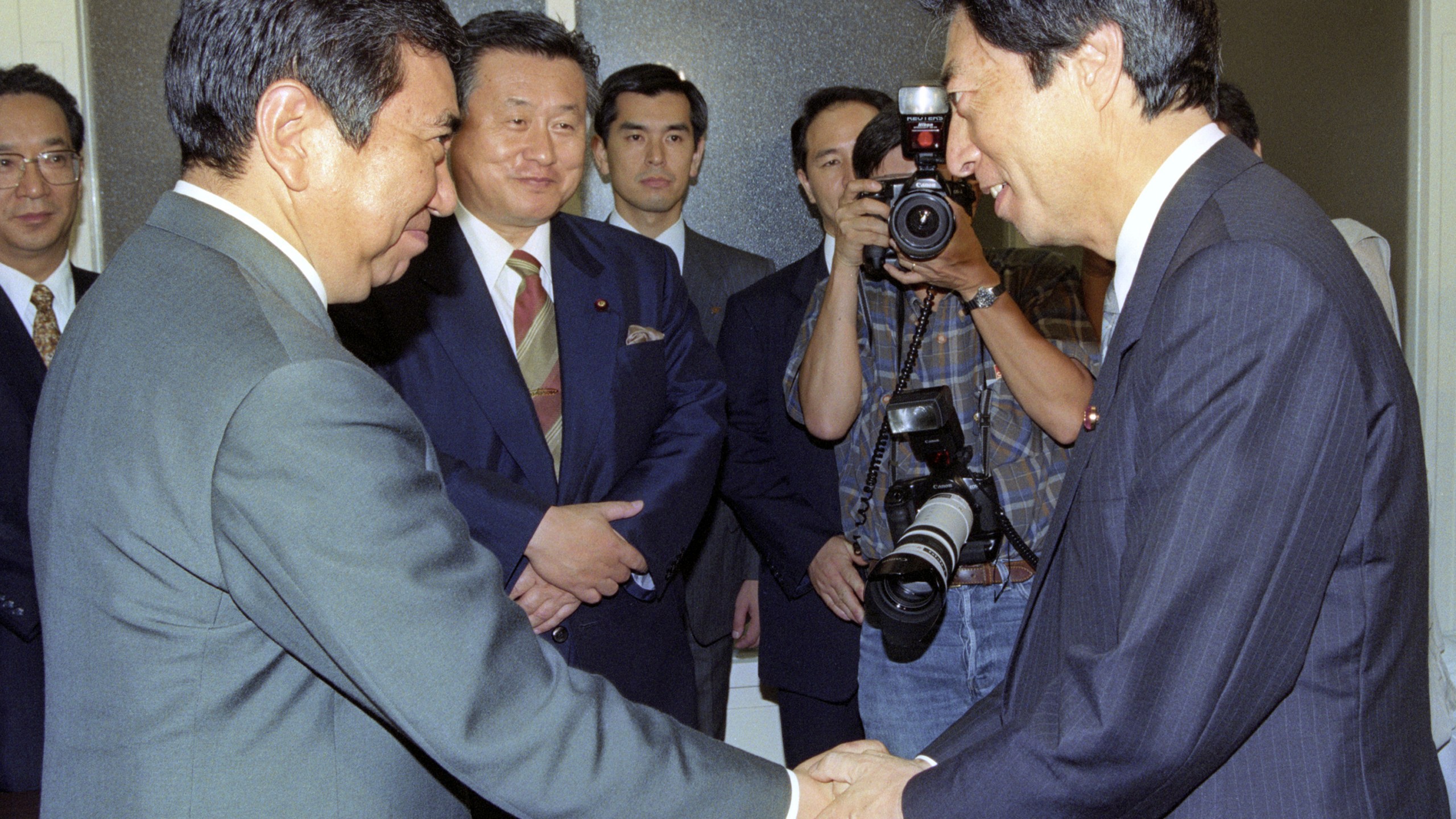 Japan's newly appointed Prime Minister Morihiro Hosokawa, right, greets the Liberal Democratic Party's President Yohei Kono, left, at the parliament in Tokyo, on Aug. 6, 1993. (Kyodo News via AP)