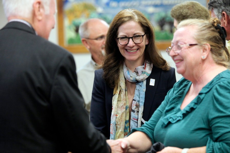 Kansas State Board of Education member Melanie Haas, center, D-Overland Park, watches as the winner of a national competition for school bus drivers is congratulated during a break in the board's regular monthly meeting, Wednesday, Oct. 9, 2024, in Topeka, Kan. (AP Photo/John Hanna)