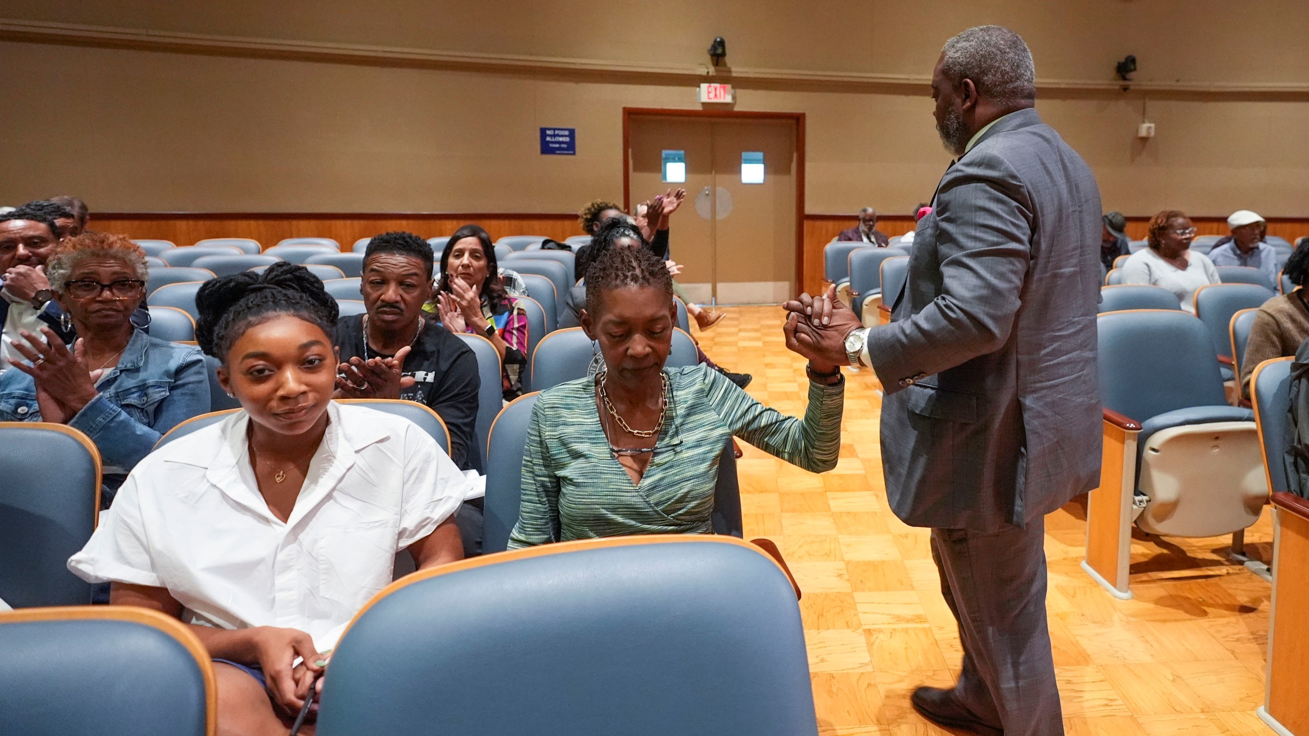 Sundiata Haley, son of Oretha Castle Haley, is congratulated by civil rights attorney Tracy L. Washington, as he walks to his seat after speaking during a city council hearing regarding the dispute over Oretha Castle Haley's former home, and plans by others to create a museum, in New Orleans, Thursday, Oct. 24, 2024. (AP Photo/Gerald Herbert)