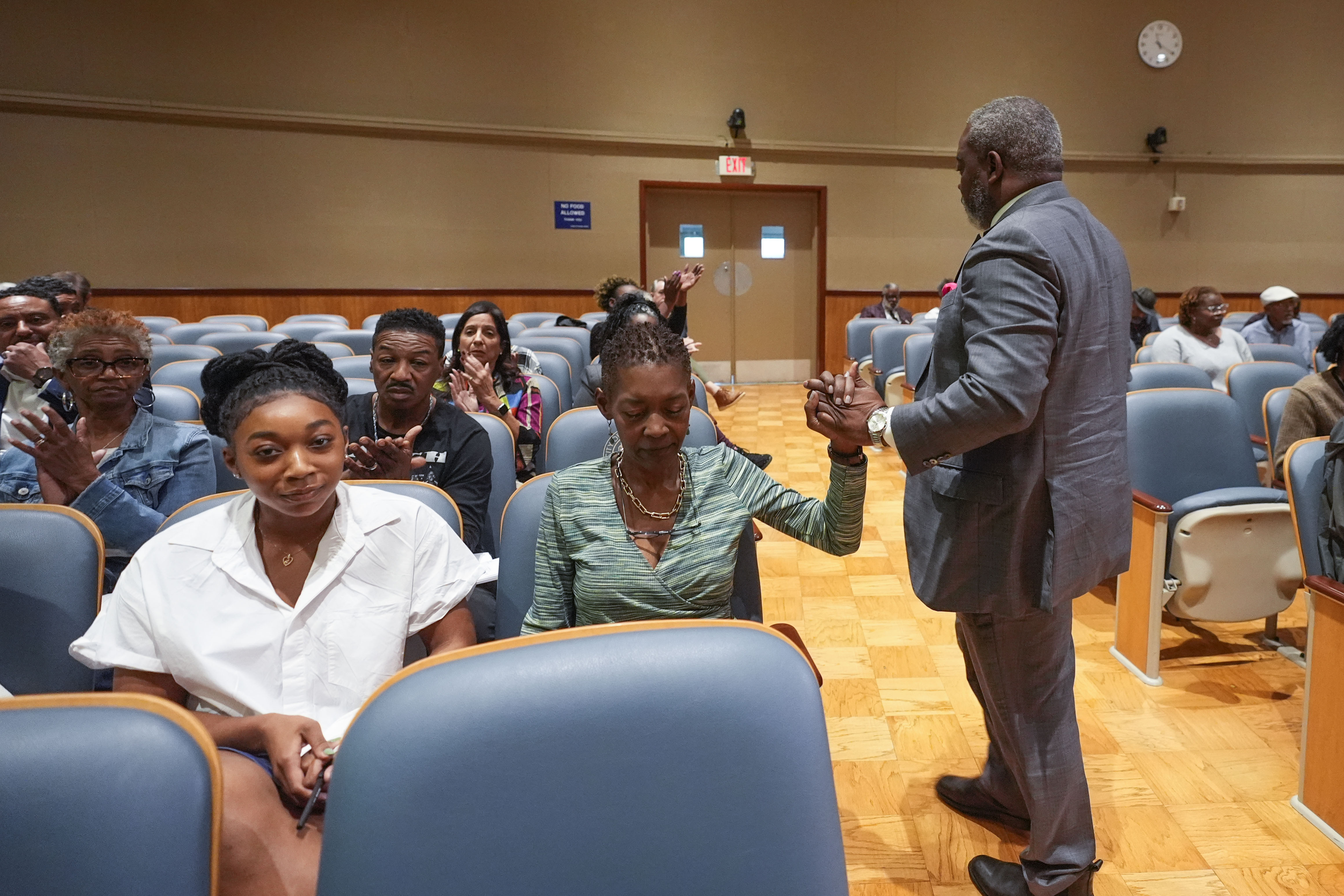 Sundiata Haley, son of Oretha Castle Haley, is congratulated by civil rights attorney Tracy L. Washington, as he walks to his seat after speaking during a city council hearing regarding the dispute over Oretha Castle Haley's former home, and plans by others to create a museum, in New Orleans, Thursday, Oct. 24, 2024. (AP Photo/Gerald Herbert)