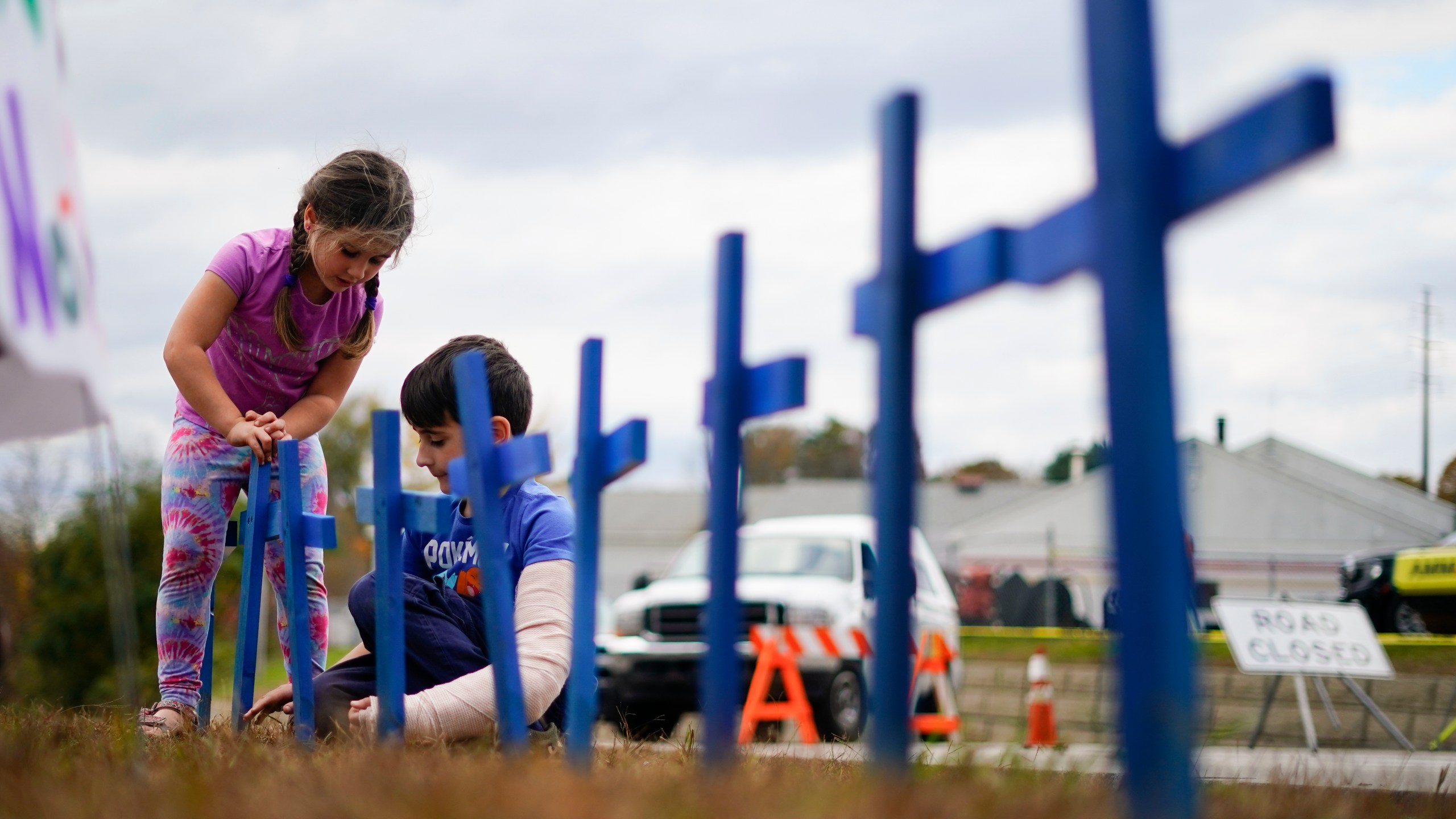 FILE - Lucy Allard, 5, and her brother Zeke Allard, 8, plant crosses in honor of the victims of this week's mass shooting in Lewiston, Maine, Oct. 28, 2023. (AP Photo/Matt Rourke)