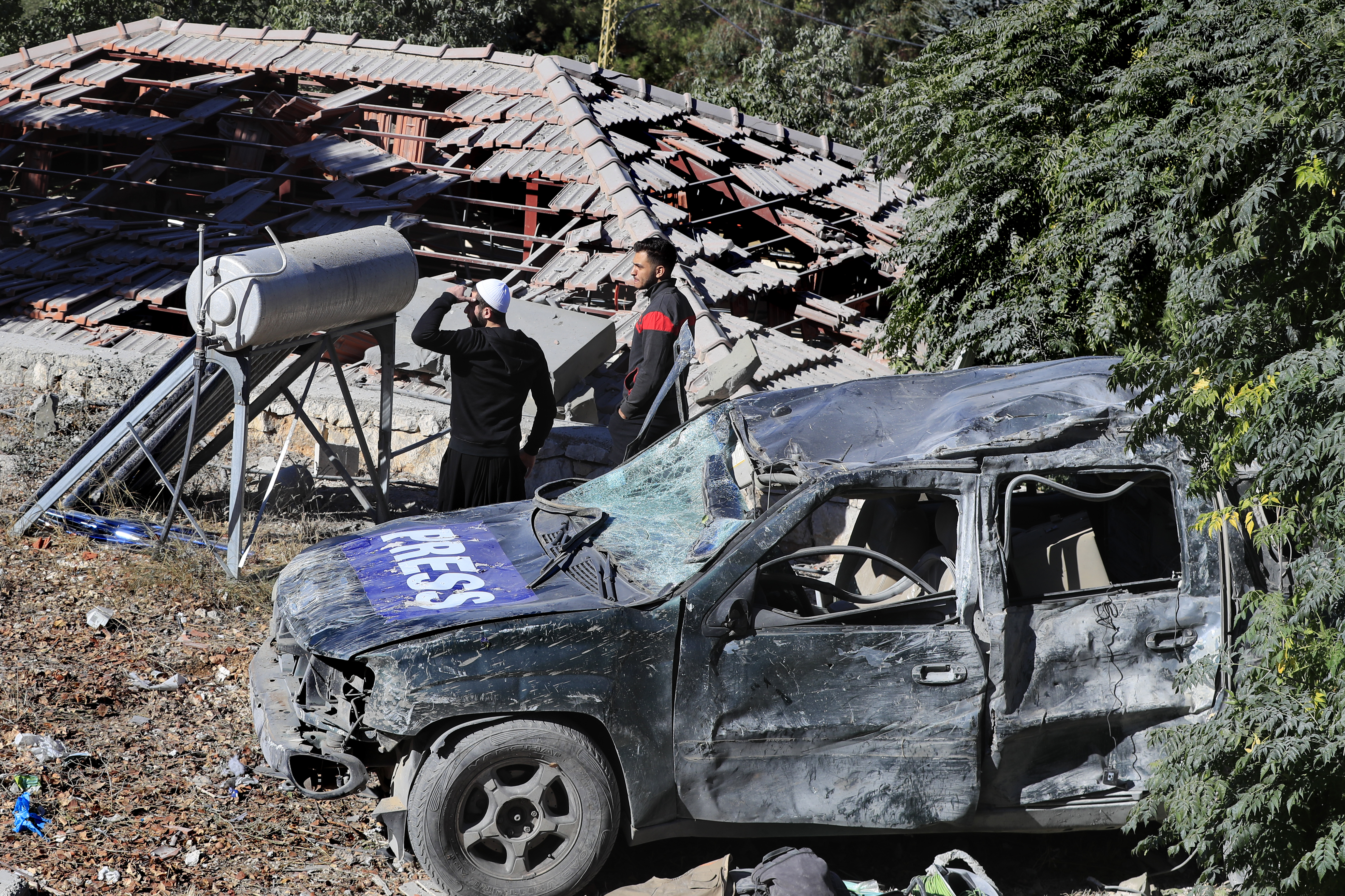 People observe the site where an Israeli airstrike hit a compound housing journalists, killing three media staffers from two different news agencies according to Lebanon's state-run National News Agency, in Hasbaya village, southeast Lebanon, Friday, Oct. 25, 2024. (AP Photo/Mohammed Zaatari)