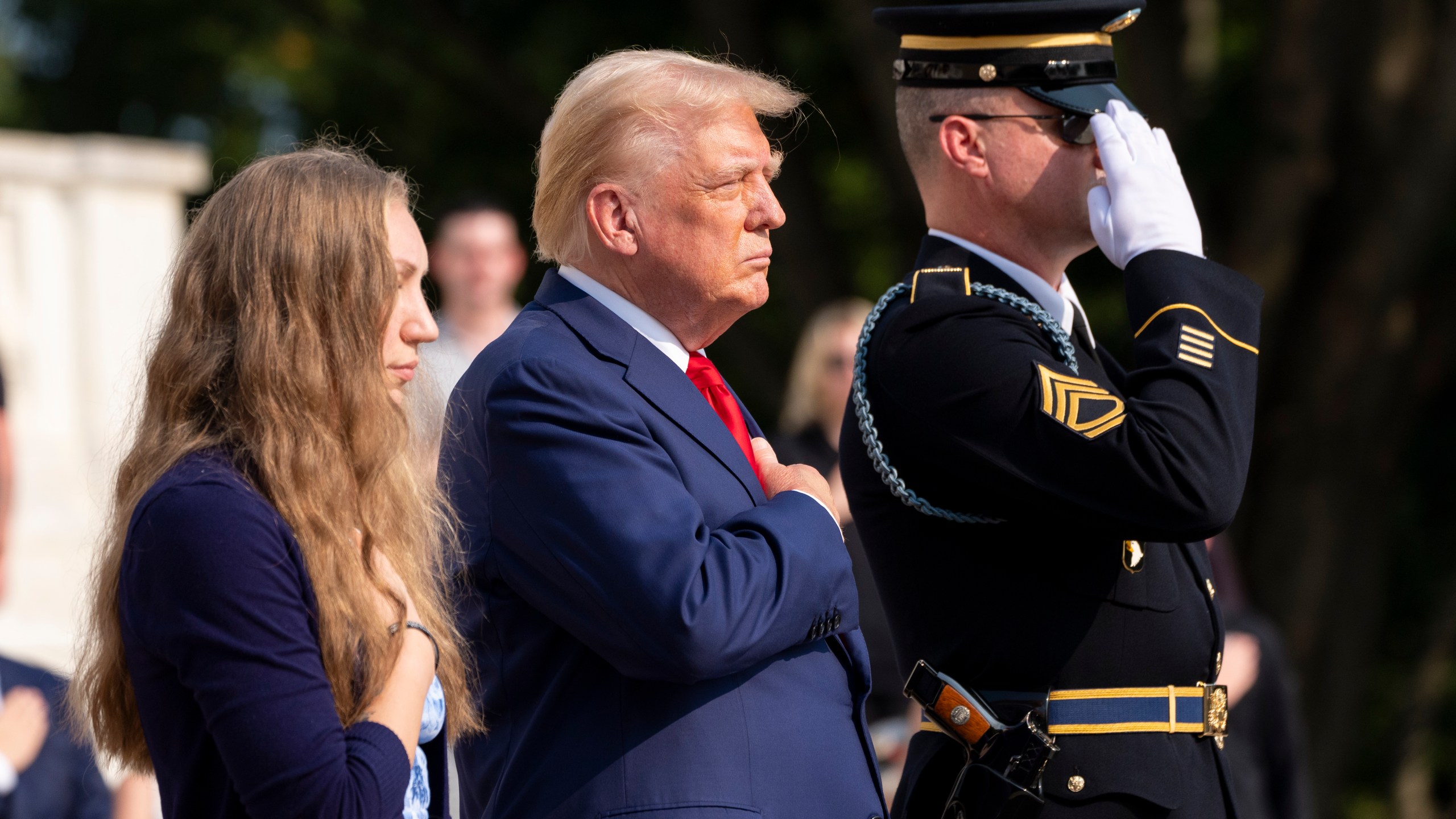 FILE - Republican presidential nominee former President Donald Trump, center and Misty Fuoco, left, sister of Nicole Gee, place their hands over their heart after placing a wreath in honor of Sgt. Nicole Gee at the Tomb of the Unknown Solider at Arlington National Cemetery, Aug. 26, 2024, in Arlington, Va. (AP Photo/Alex Brandon, File)