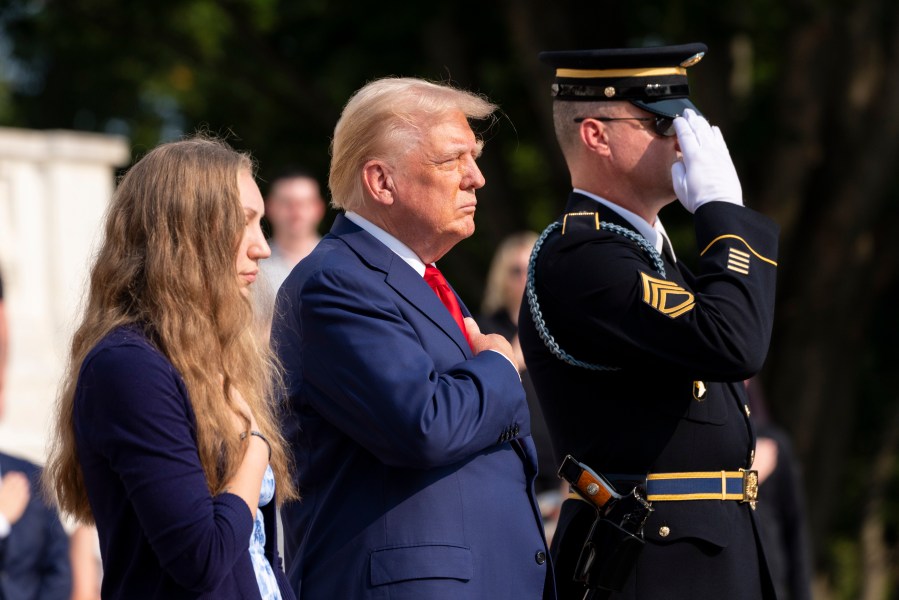 FILE - Republican presidential nominee former President Donald Trump, center and Misty Fuoco, left, sister of Nicole Gee, place their hands over their heart after placing a wreath in honor of Sgt. Nicole Gee at the Tomb of the Unknown Solider at Arlington National Cemetery, Aug. 26, 2024, in Arlington, Va. (AP Photo/Alex Brandon, File)