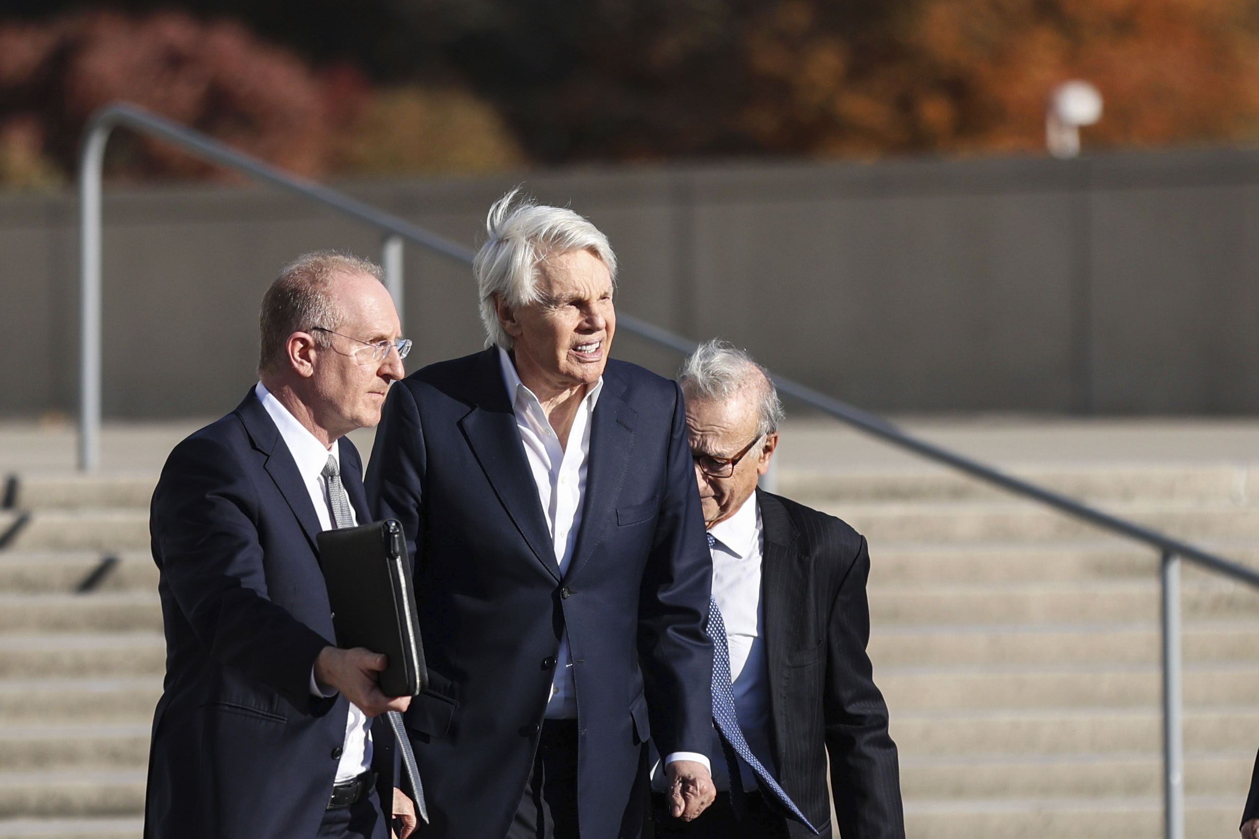 Michael Jeffries, former CEO of Abercrombie & Fitch, center, exits the federal courthouse after his arraignment on sex trafficking and interstate prostitution charges, Friday, Oct. 25, 2024, in Central Islip, N.Y. (AP Photo/Heather Khalifa)