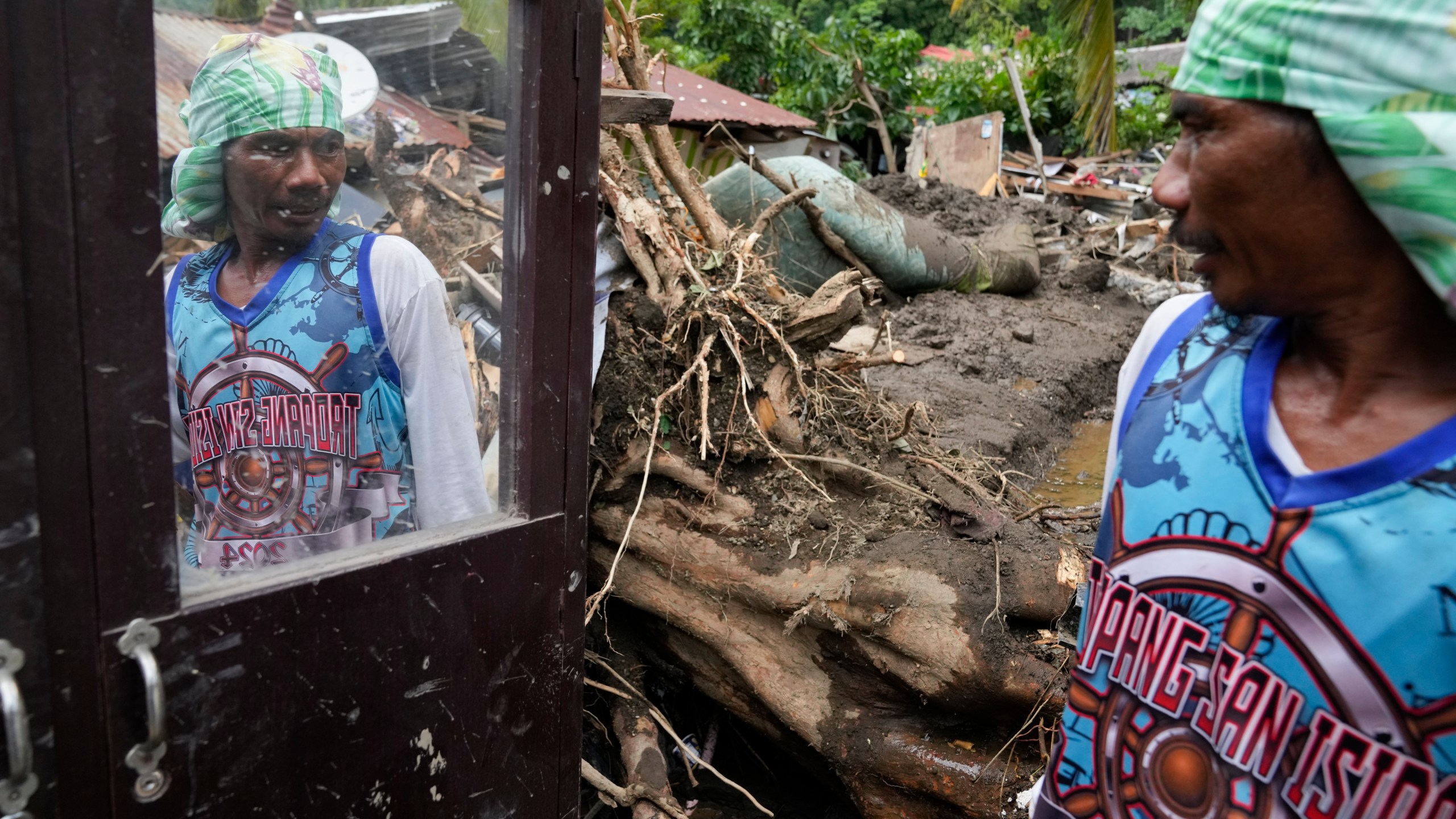 Marcelino Aringo speaks near his damaged house after a landslide triggered by Tropical Storm Trami struck homes, leaving several villagers dead in Talisay, Batangas province, Philippines on Saturday, Oct. 26, 2024. (AP Photo/Aaron Favila)