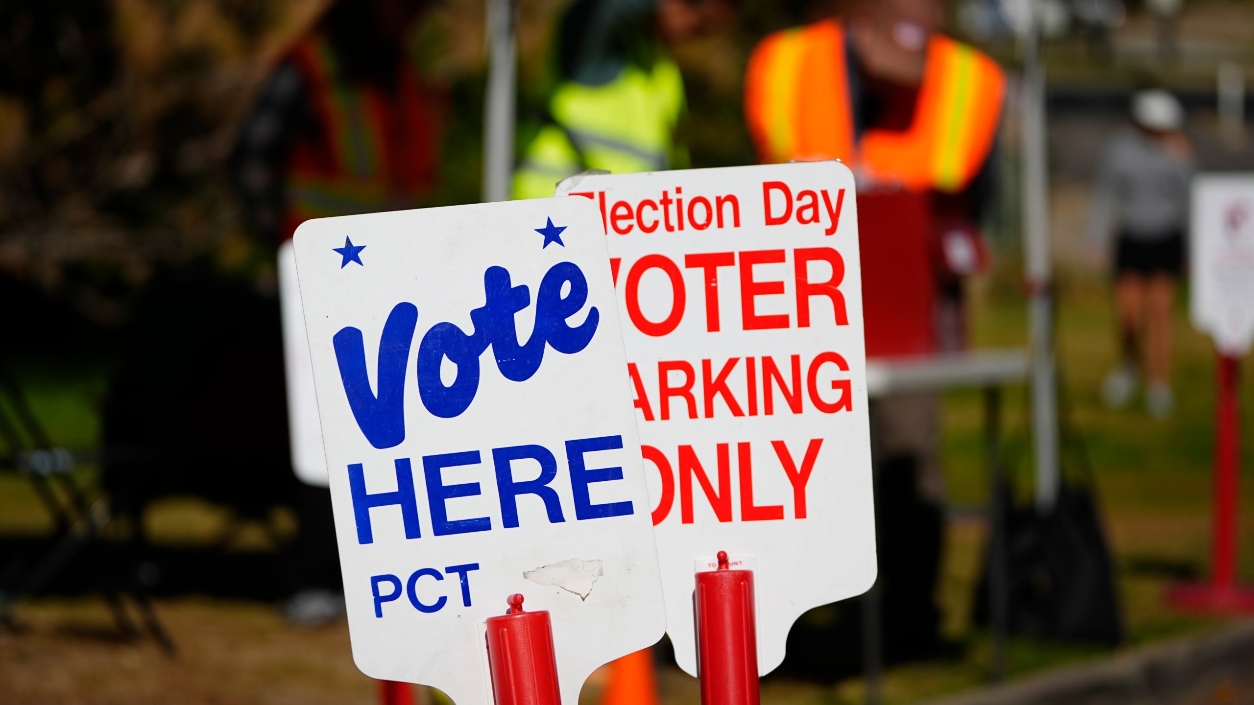 Signs direct voters to a ballot drop-off location Friday, Oct. 25, 2024, in Washington Park in Denver. (AP Photo/David Zalubowski)