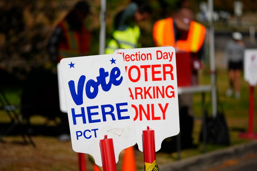 Signs direct voters to a ballot drop-off location Friday, Oct. 25, 2024, in Washington Park in Denver. (AP Photo/David Zalubowski)