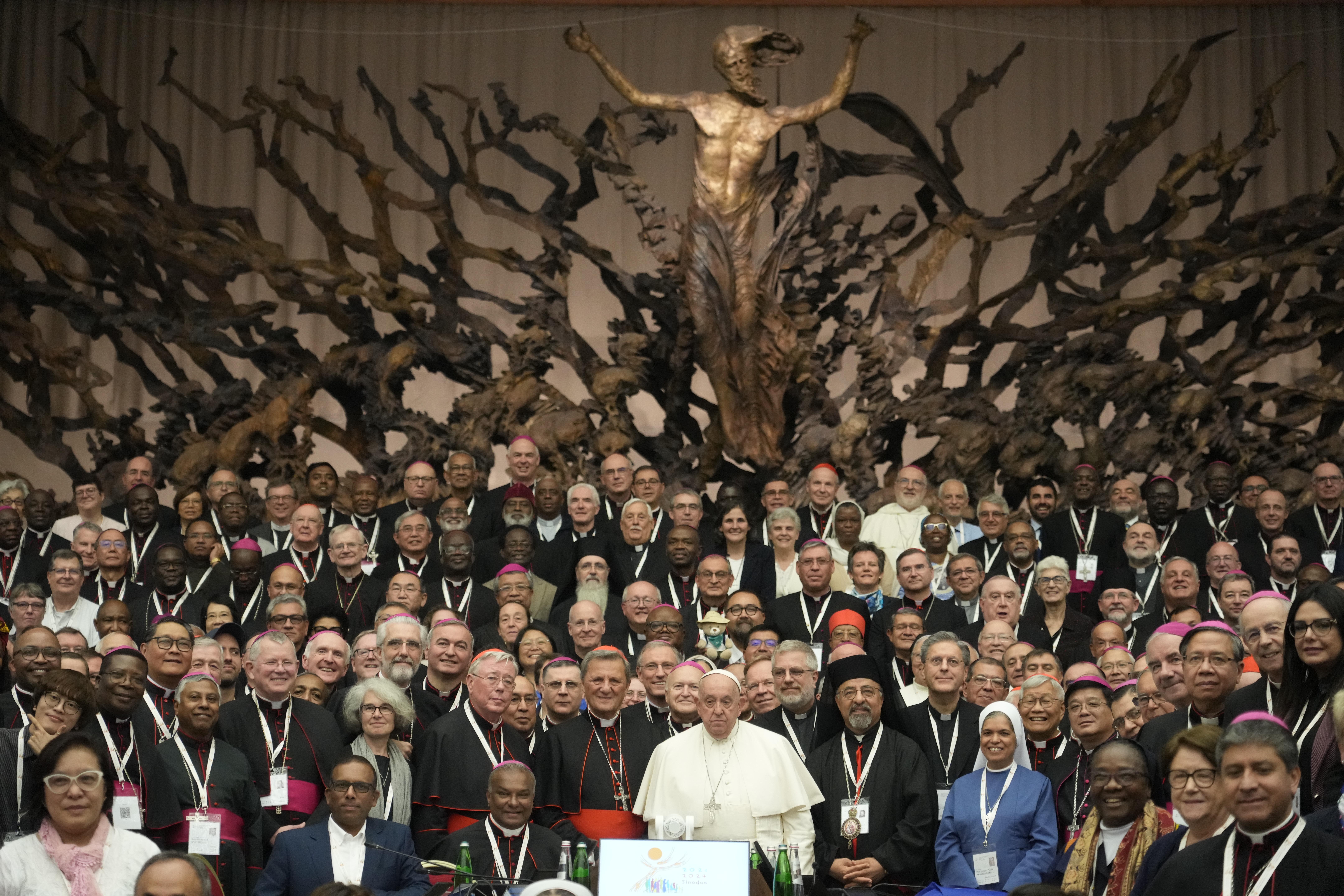 Pope Francis, background center, poses with the participants to the second session of the 16th General Assembly of the Synod of Bishops gather in the Paul VI hall, at the Vatican, Saturday, Oct. 26, 2024. (AP Photo/Gregorio Borgia)