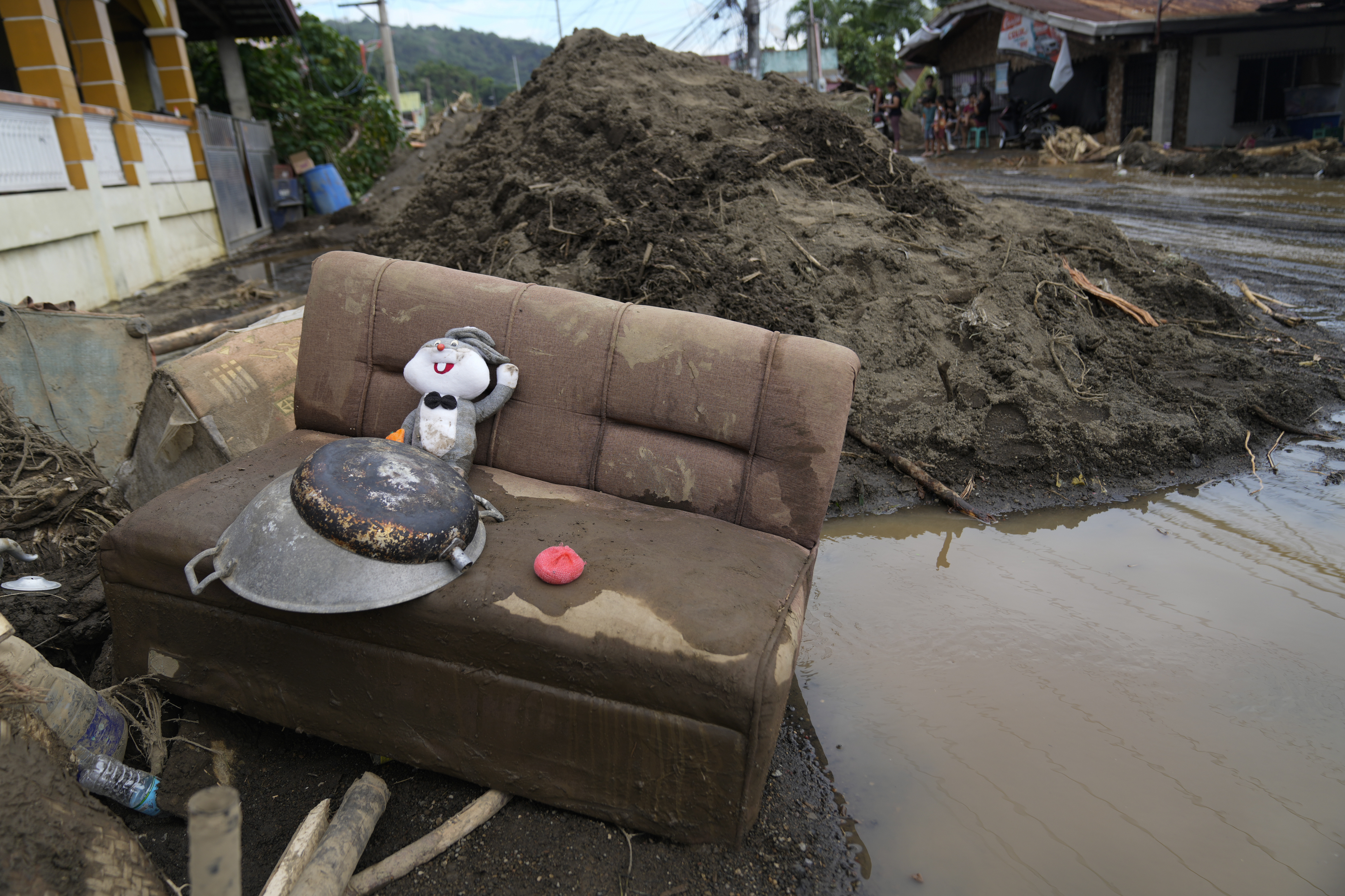 A rabbit doll sits on a mud-covered sofa after a landslide triggered by Tropical Storm Trami struck homes in Talisay, Batangas province, Philippines on Saturday, Oct. 26, 2024. (AP Photo/Aaron Favila)