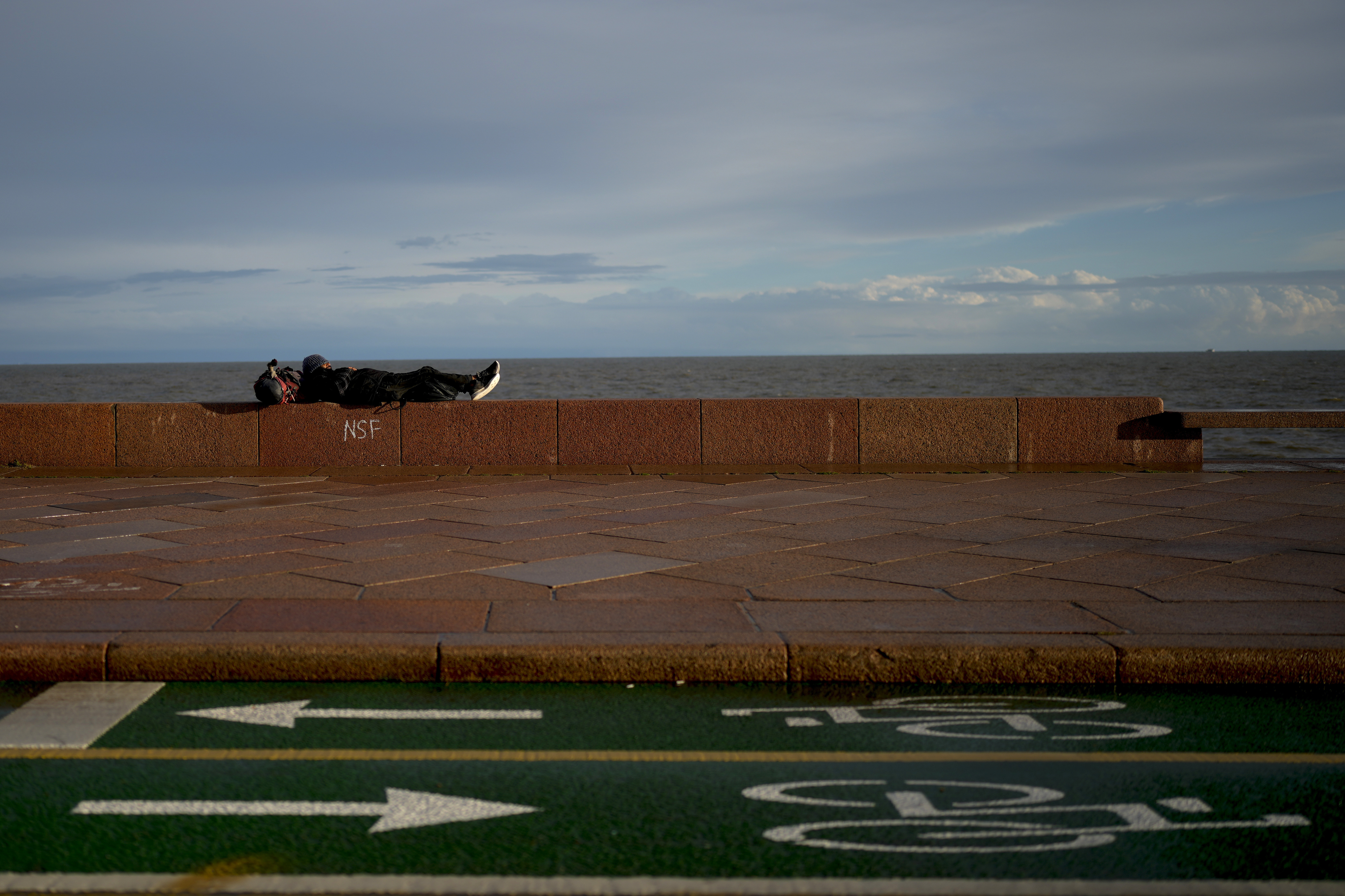 A man rests the wall of a promenade ahead of Sunday's general election, in Montevideo, Uruguay, Friday, Oct. 25, 2024. (AP Photo/Natacha Pisarenko)