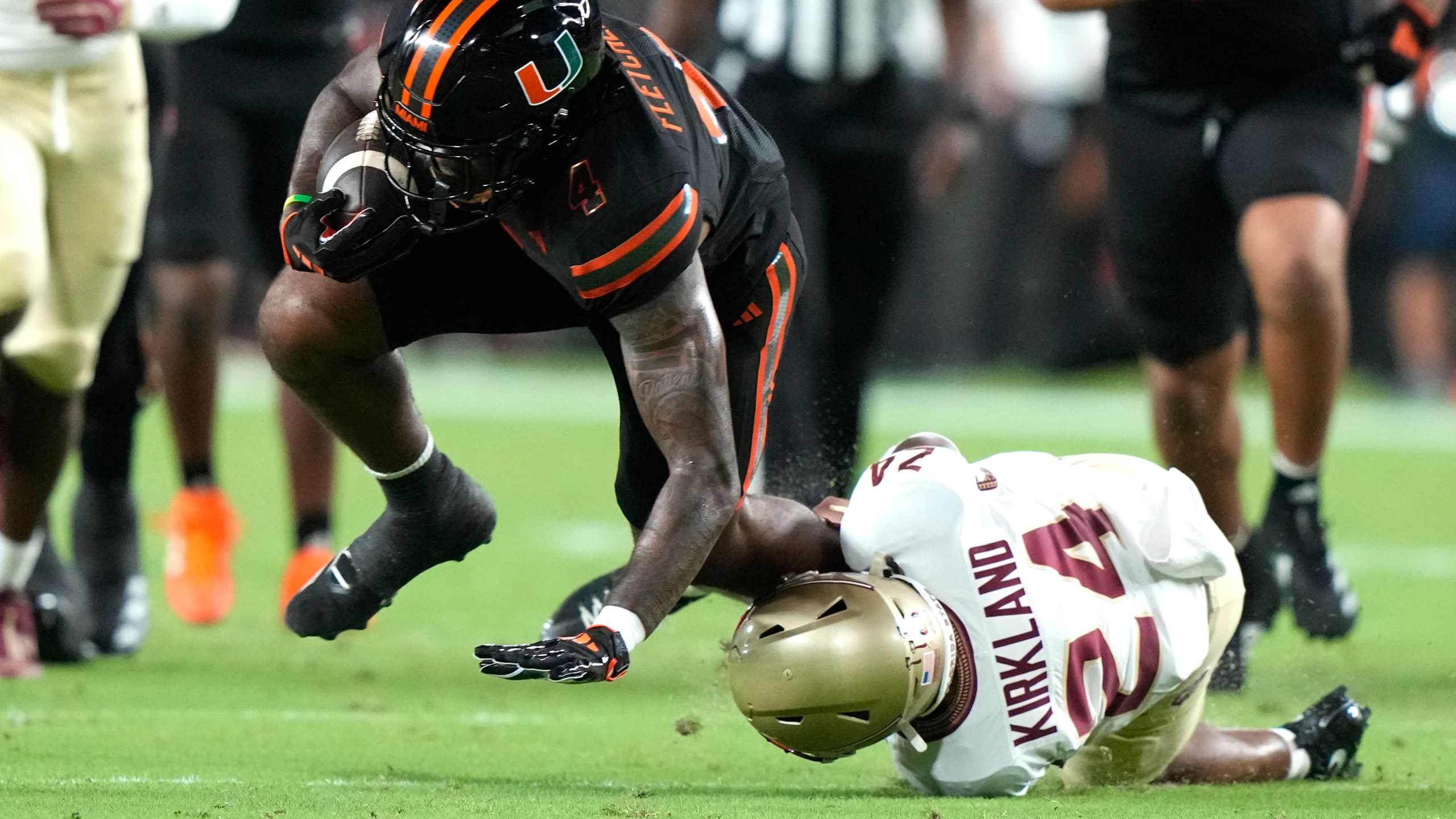 Miami running back Mark Fletcher Jr., left, runs for a first down as Florida State defensive back K.J. Kirkland (24) defends during the first half of an NCAA college football game, Saturday, Oct. 26, 2024, in Miami Gardens, Fla. (AP Photo/Lynne Sladky)