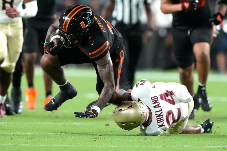 Miami running back Mark Fletcher Jr., left, runs for a first down as Florida State defensive back K.J. Kirkland (24) defends during the first half of an NCAA college football game, Saturday, Oct. 26, 2024, in Miami Gardens, Fla. (AP Photo/Lynne Sladky)