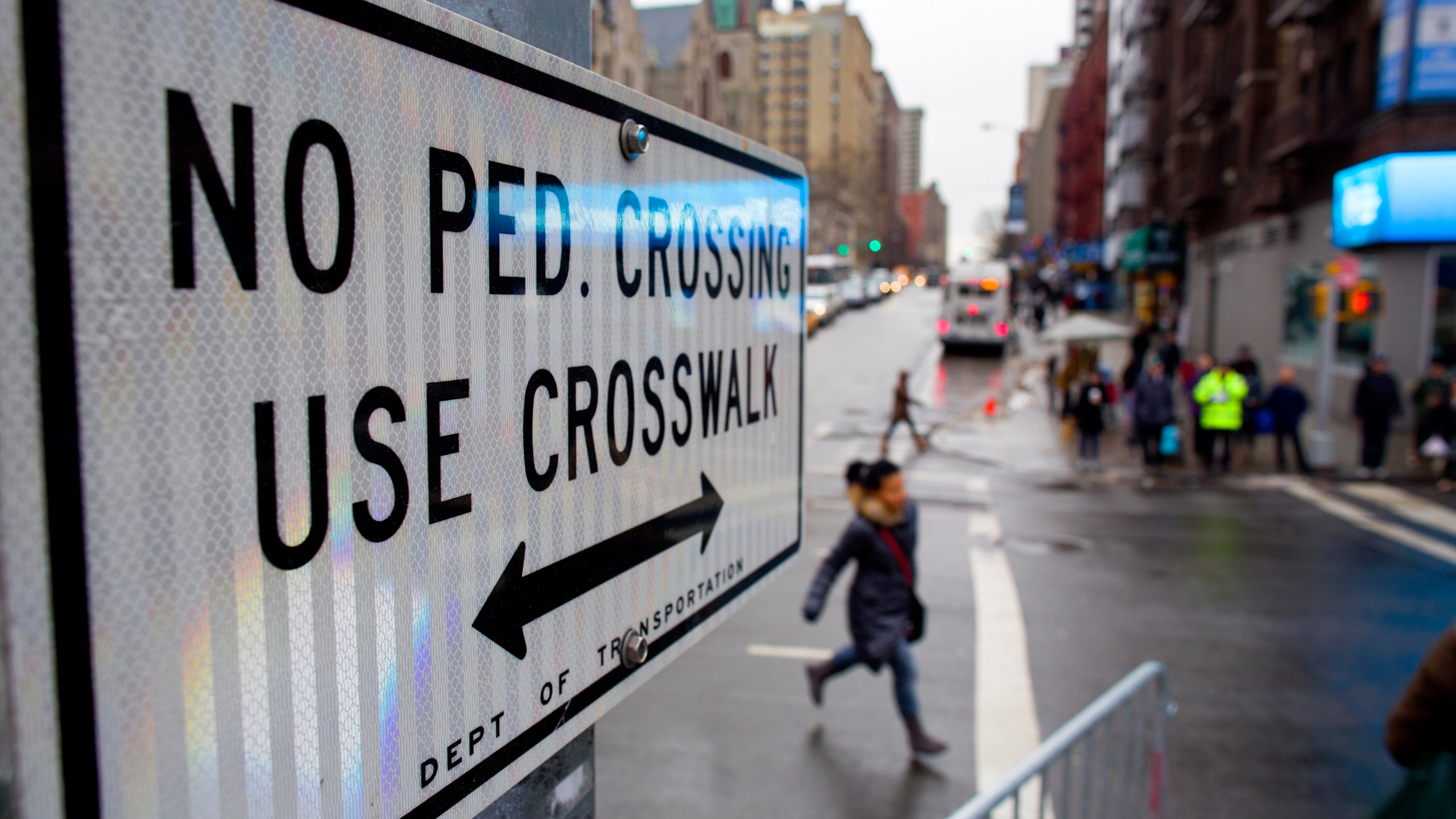 FILE - After crossing outside a crosswalk, a pedestrian, center, runs towards a crosswalk at the busy intersection of W. 96th Street and Broadway in the Upper West Side of New York Monday, Jan. 27, 2014. (AP Photo/Craig Ruttle, File)