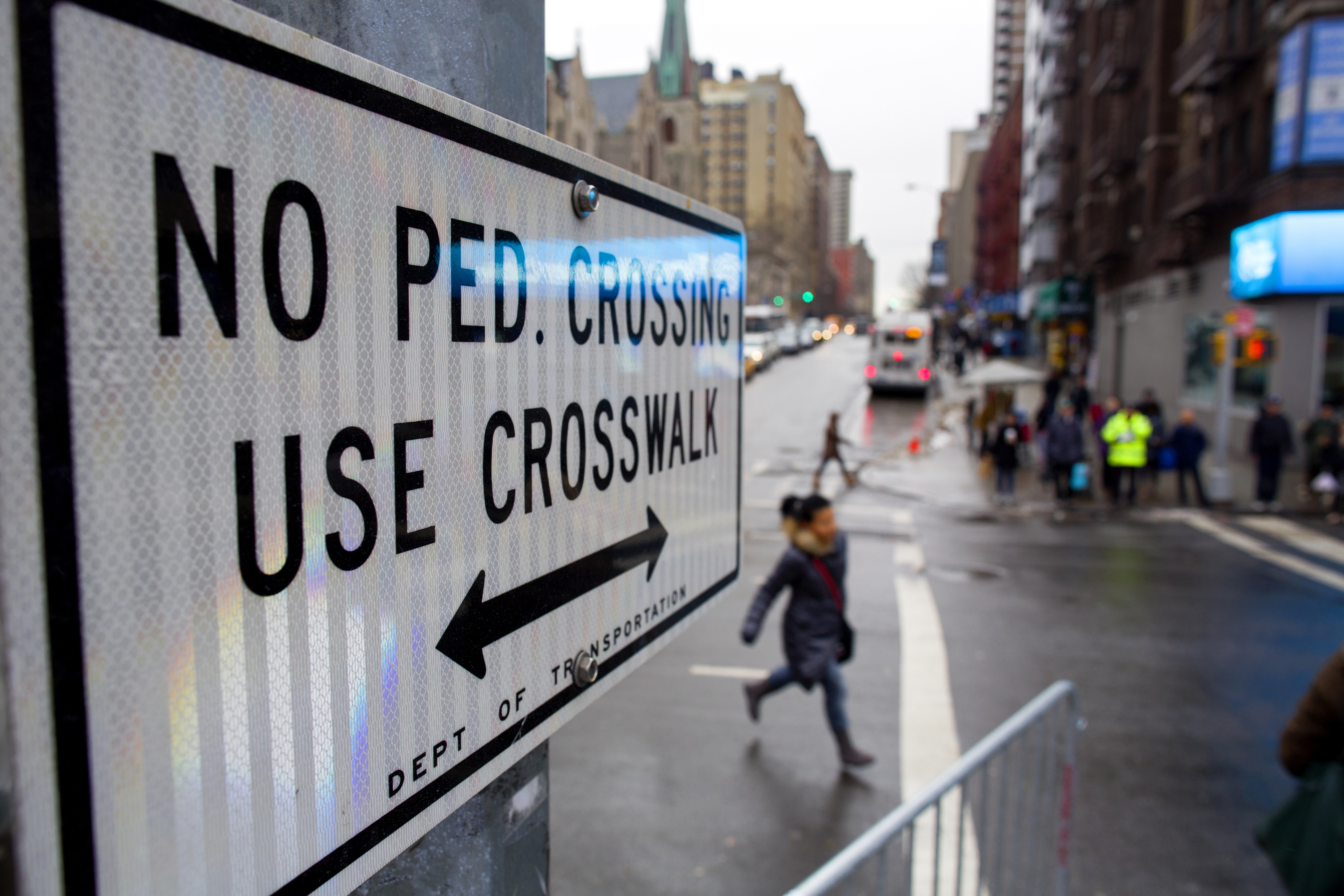 FILE - After crossing outside a crosswalk, a pedestrian, center, runs towards a crosswalk at the busy intersection of W. 96th Street and Broadway in the Upper West Side of New York Monday, Jan. 27, 2014. (AP Photo/Craig Ruttle, File)