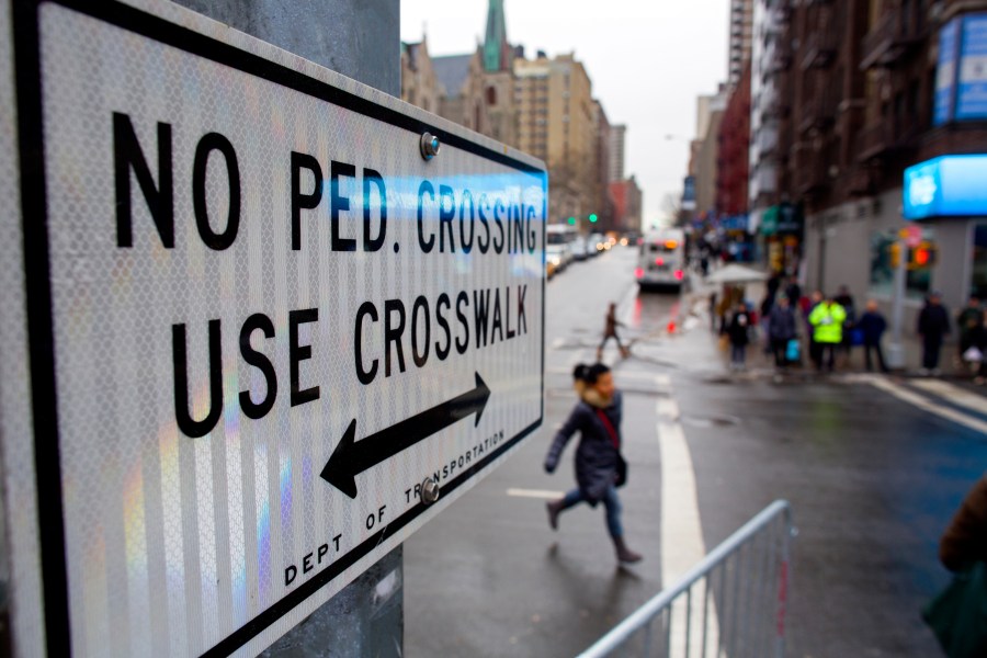 FILE - After crossing outside a crosswalk, a pedestrian, center, runs towards a crosswalk at the busy intersection of W. 96th Street and Broadway in the Upper West Side of New York Monday, Jan. 27, 2014. (AP Photo/Craig Ruttle, File)