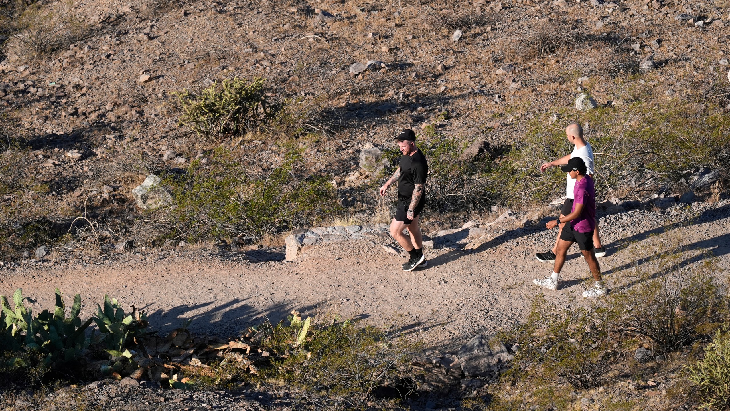 Hikers walk a trail near "A" Mountain Tuesday, Sept. 24, 2024, in Tempe, Ariz. (AP Photo/Ross D. Franklin)