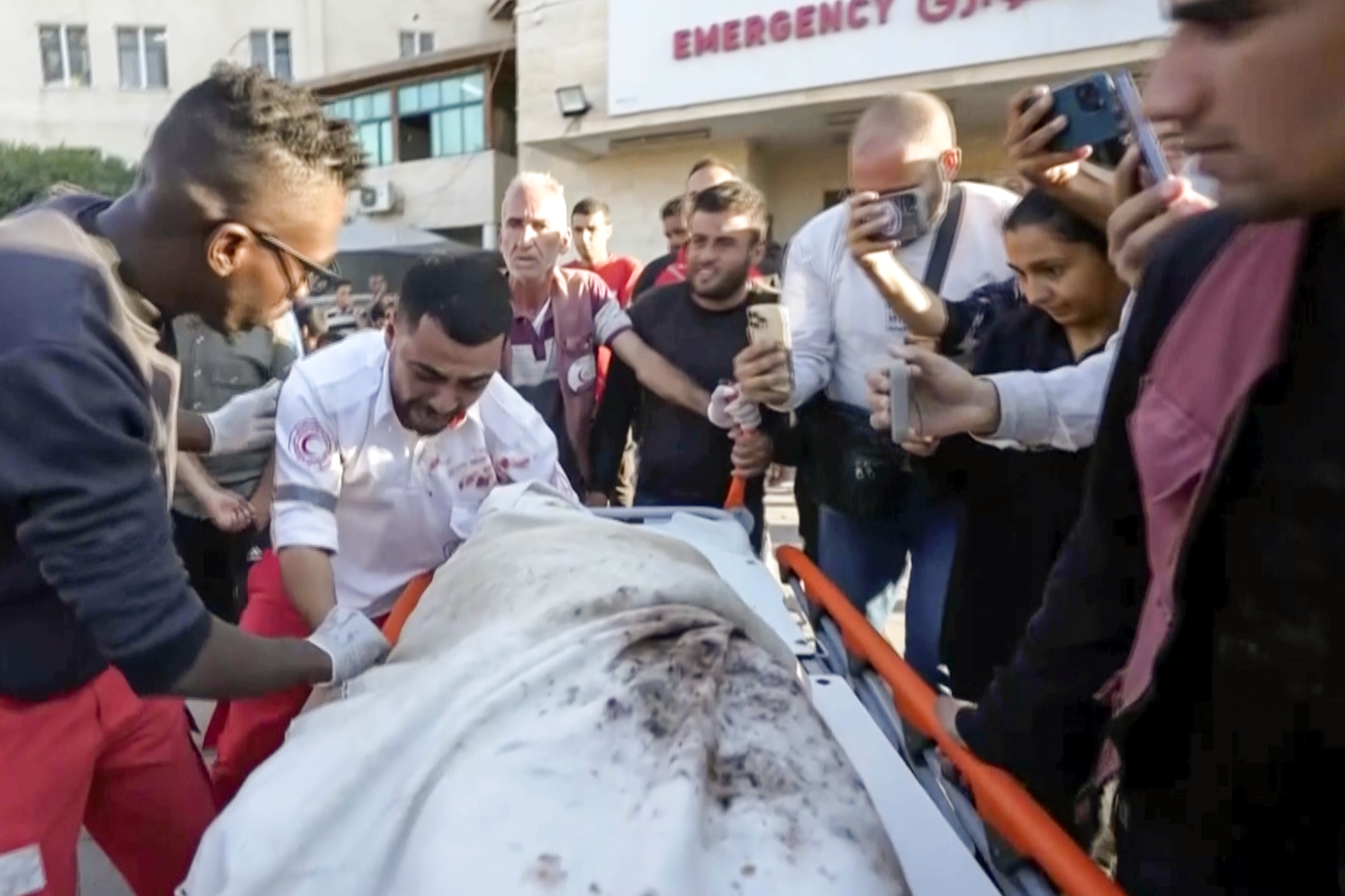 In this image made from an Associated Press video, medic Abed Al Aziz Bardini cries over the body of his mother after he realizes it's her, shouting in Arabic, "Oh god, I swear she is my mother. I didn't know it was her," on Wednesday, Oct. 30, 2024, in Deir al-Balah on the Gaza Strip. (AP Photo/Abed Al Kareem Hana)